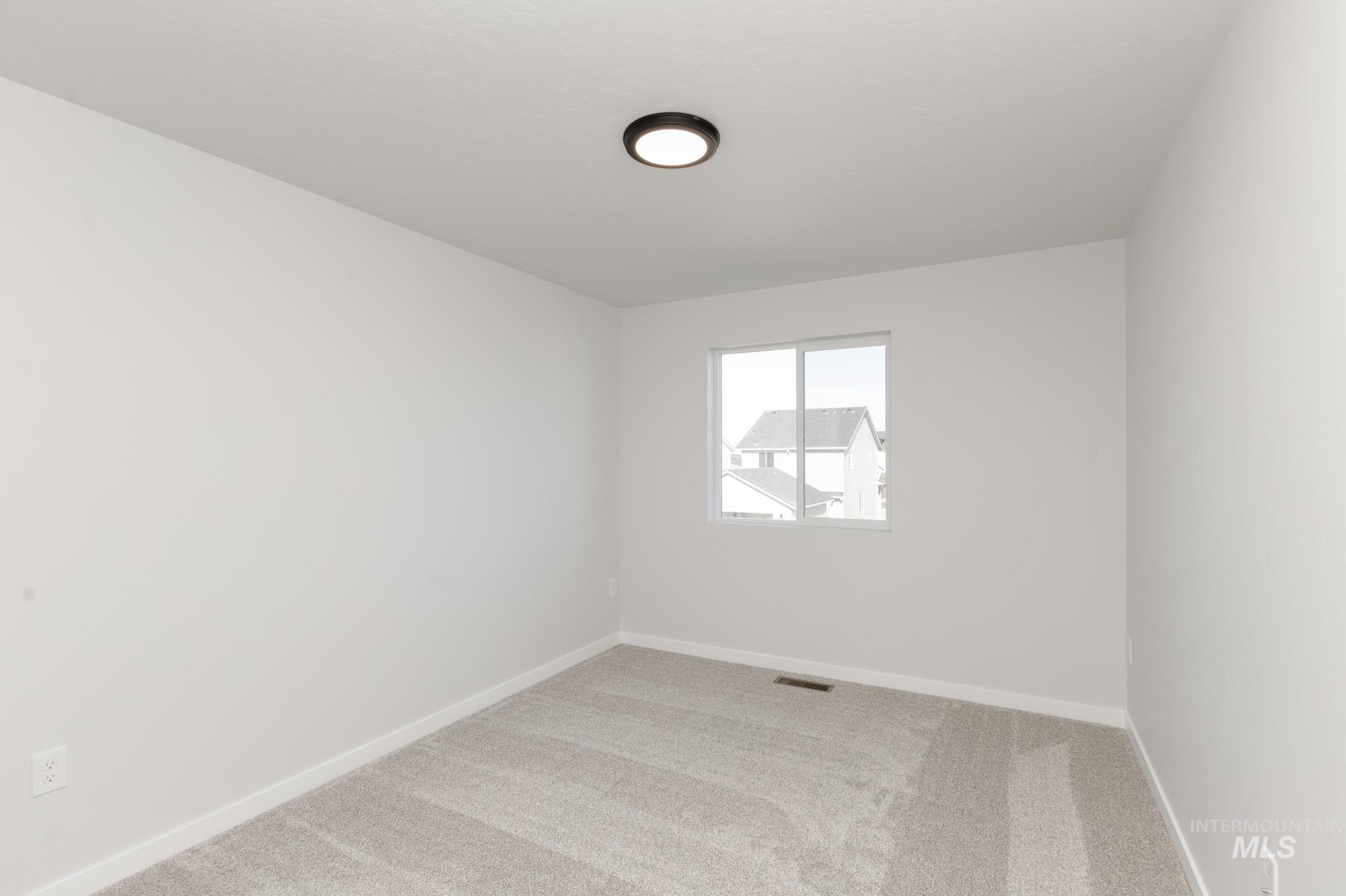 Empty room featuring light colored carpet