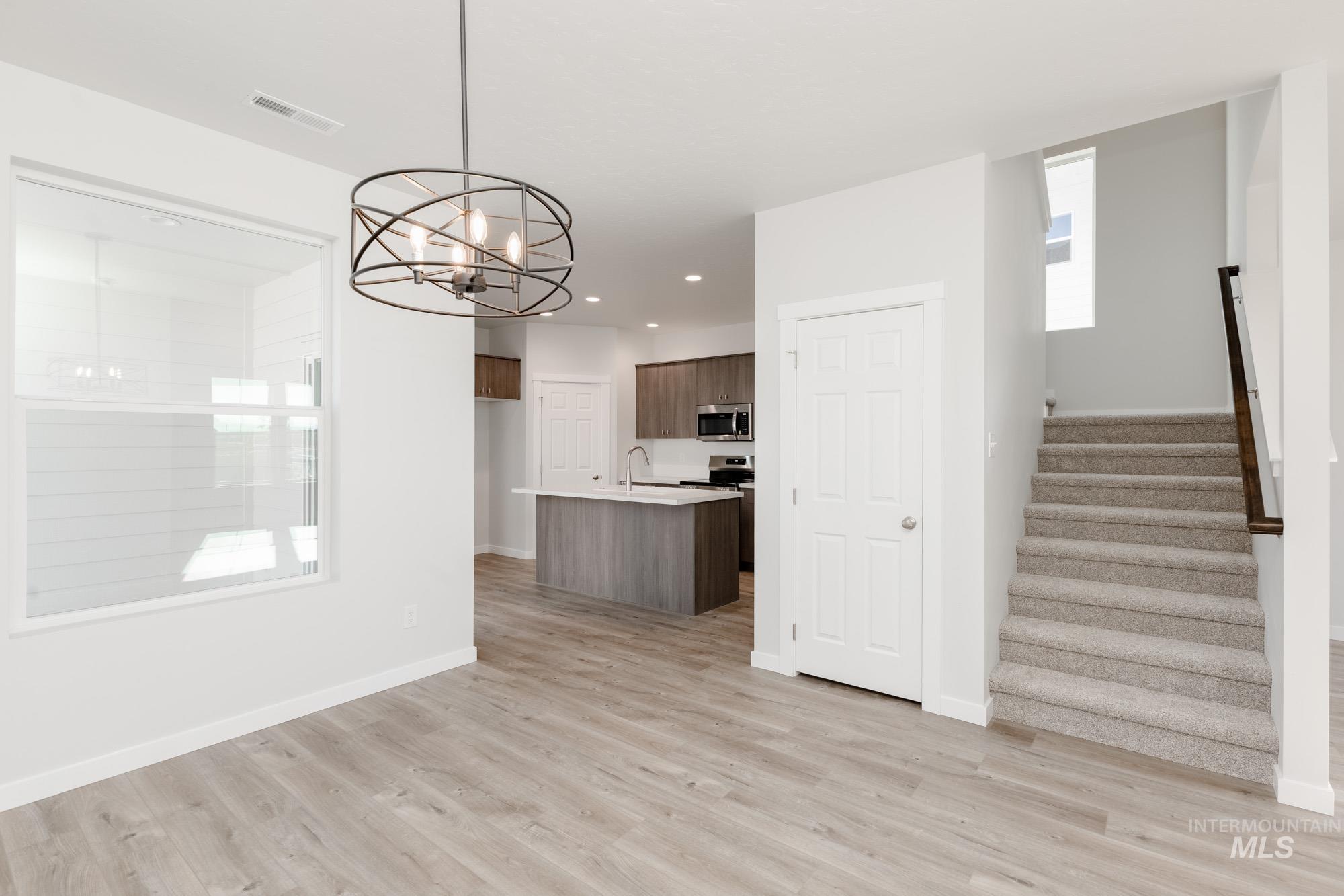 Kitchen featuring a center island with sink, decorative light fixtures, a chandelier, open floor plan, and recessed lighting