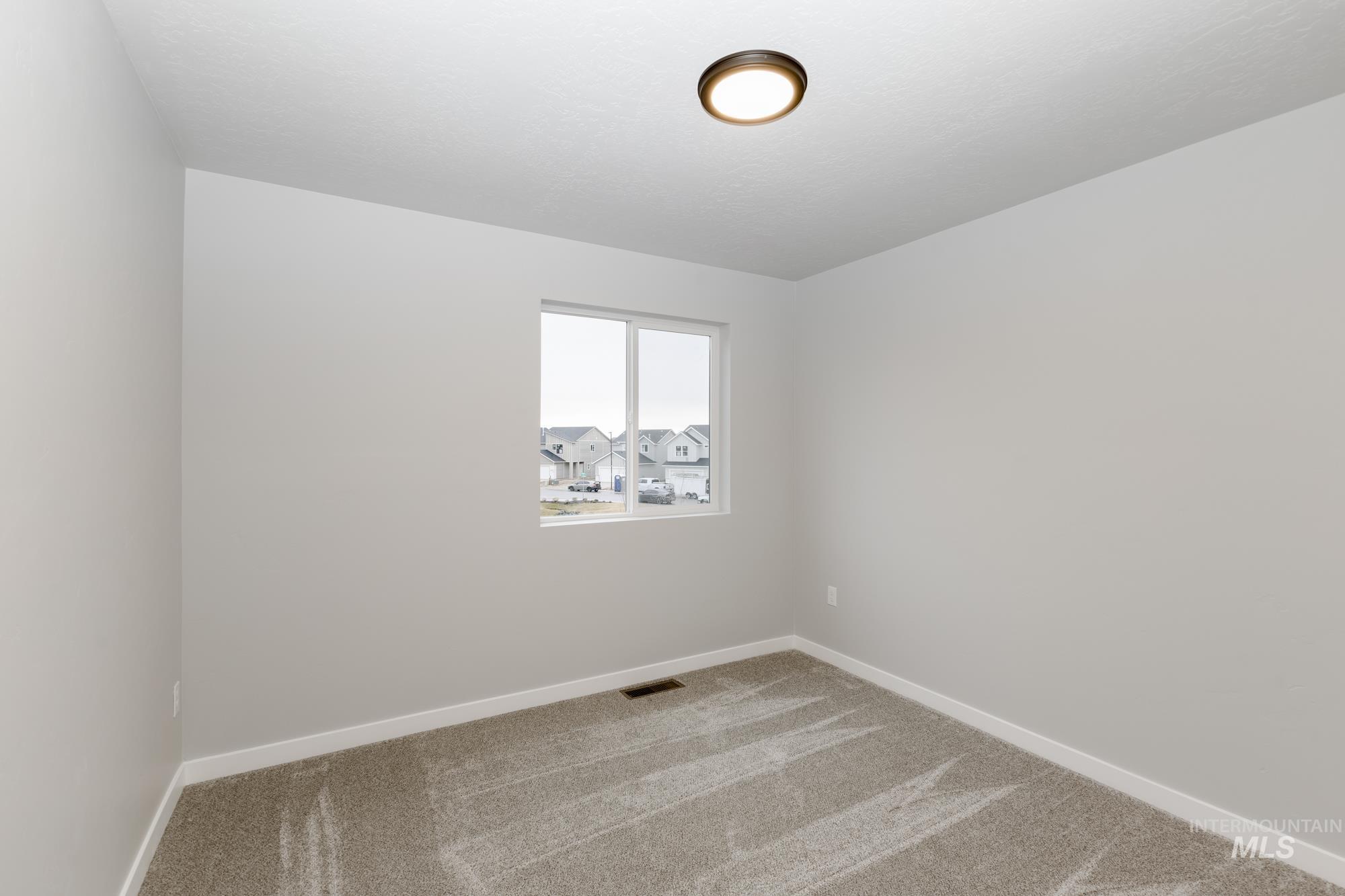 Carpeted spare room with baseboards
