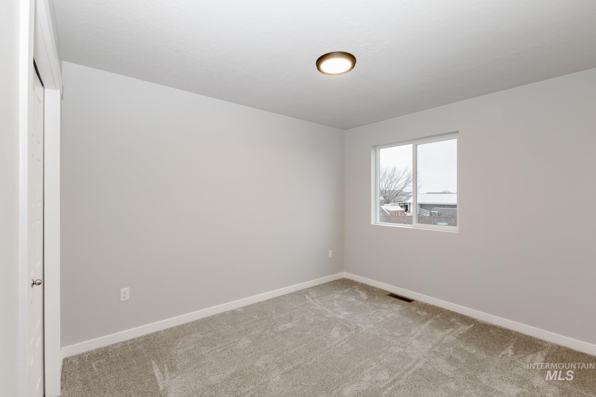Unfurnished room with baseboards and carpet