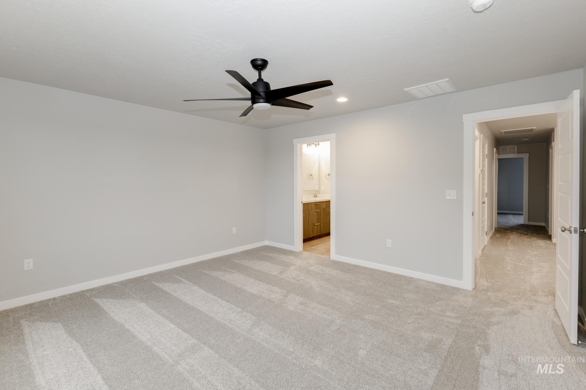 Unfurnished bedroom with light colored carpet, a ceiling fan, recessed lighting, and ensuite bathroom
