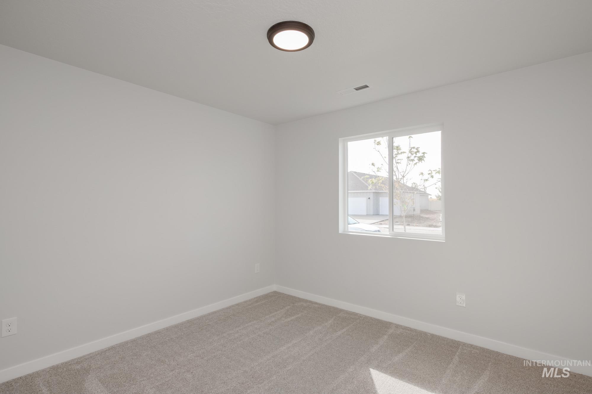 Carpeted spare room with baseboards