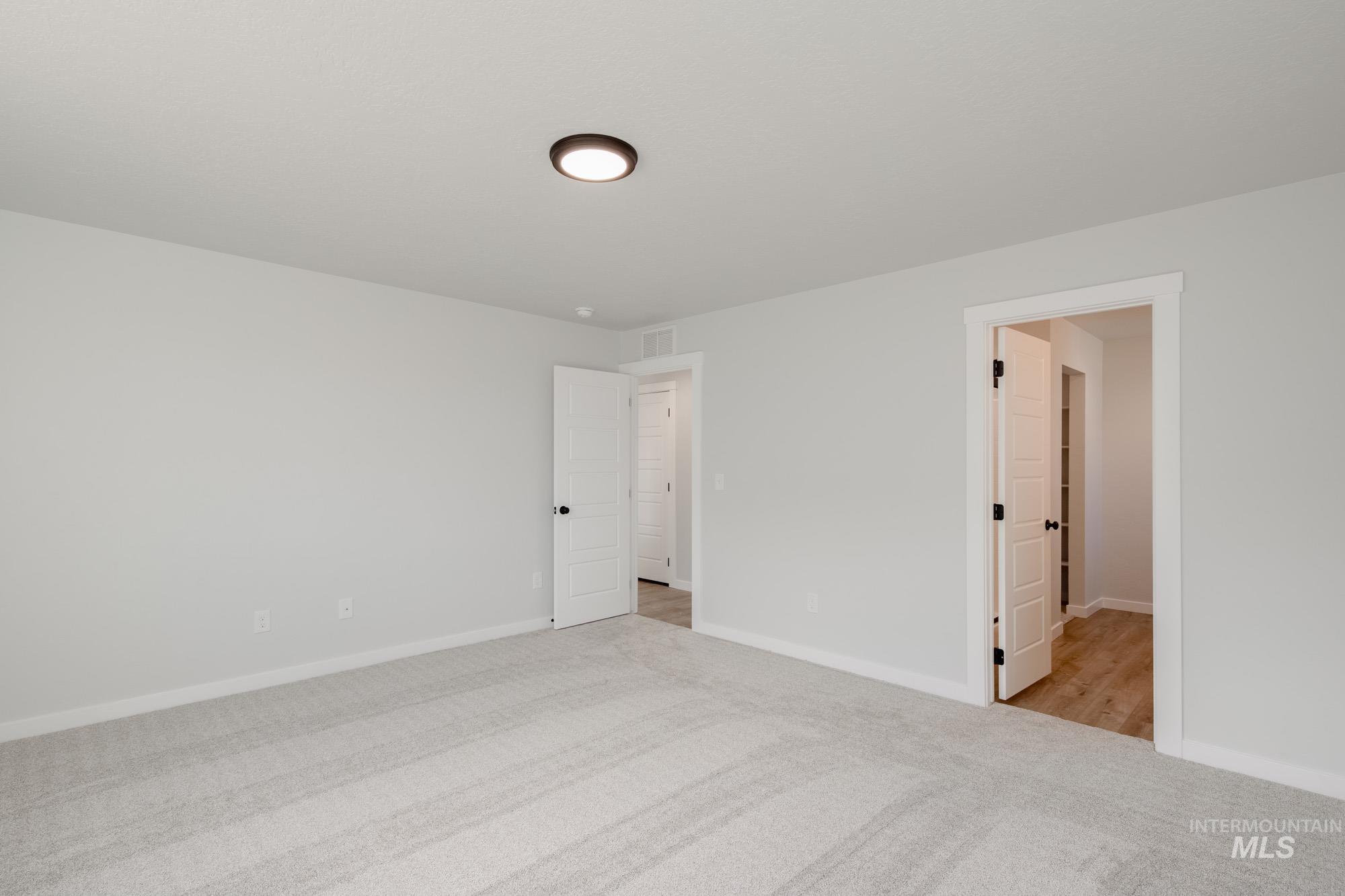 Unfurnished room with light colored carpet and baseboards