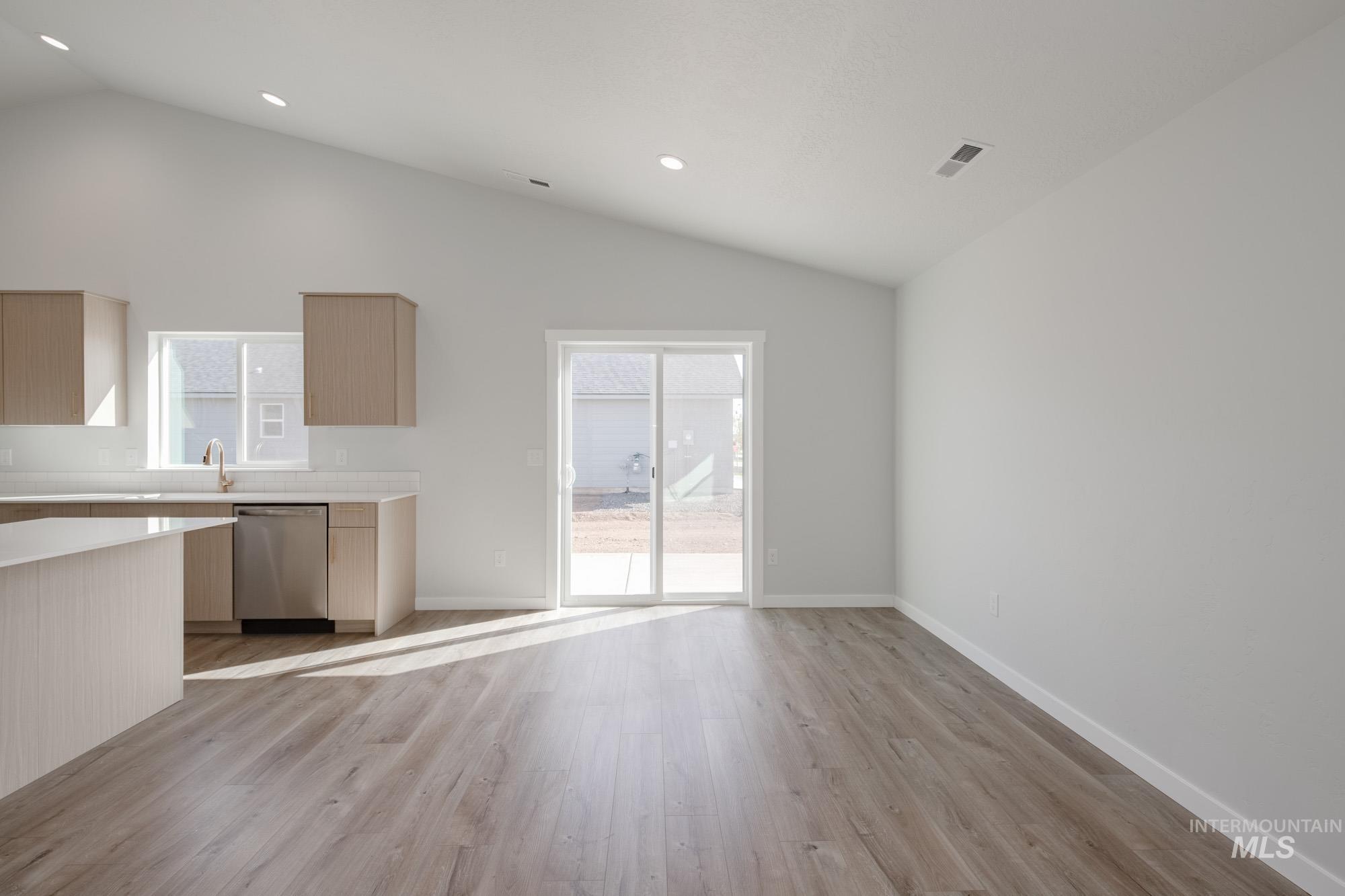 Unfurnished dining area featuring lofted ceiling, light wood-type flooring, and recessed lighting