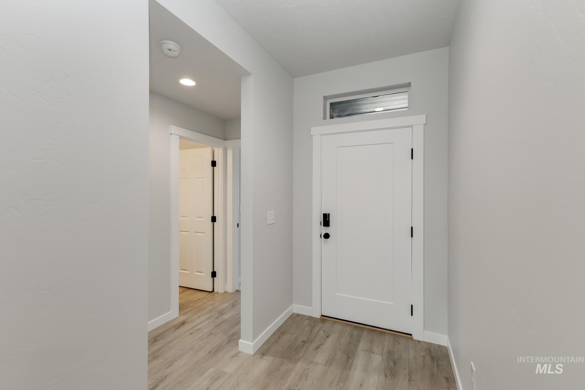 Entrance foyer with baseboards and light wood finished floors