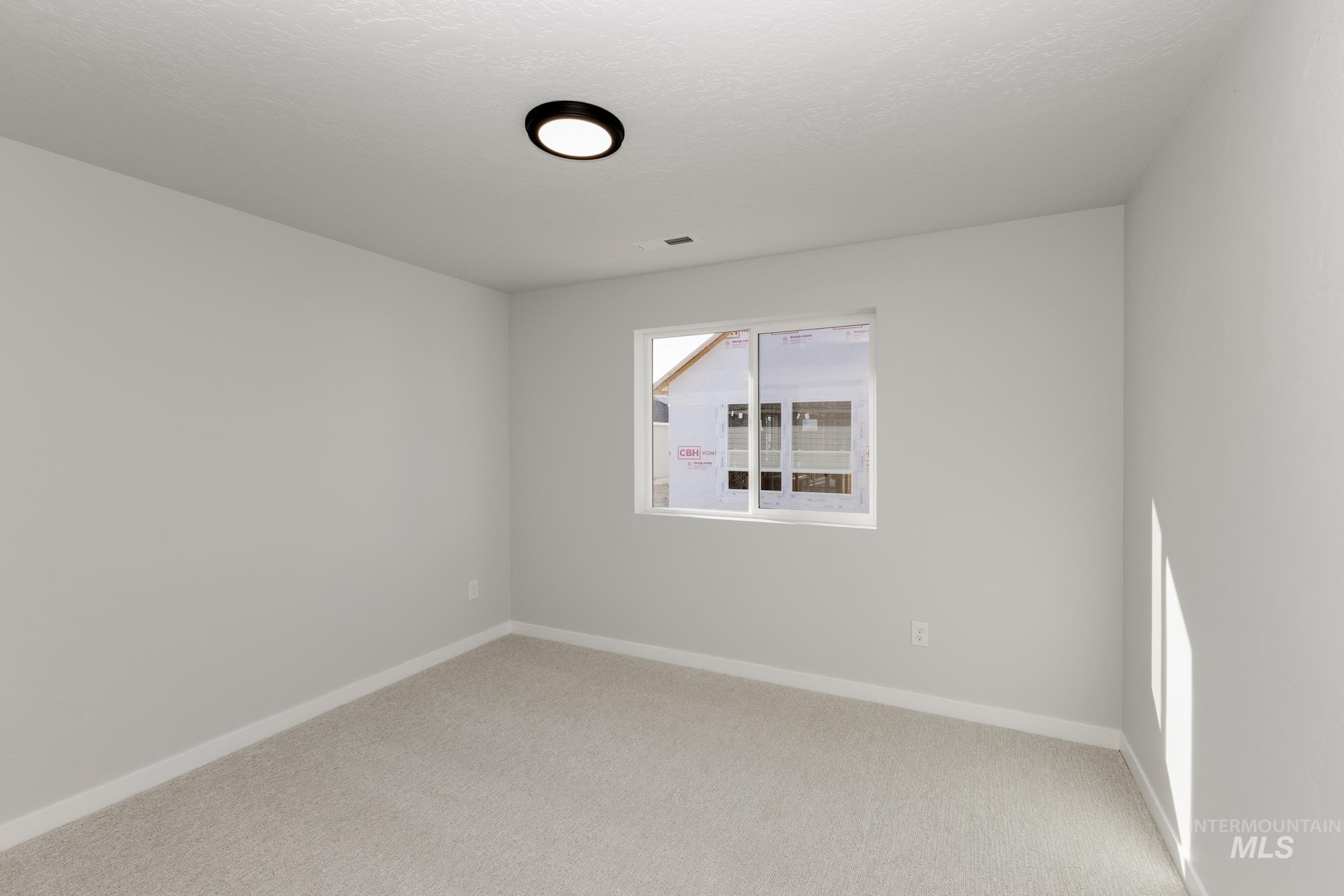 Unfurnished room with baseboards and light colored carpet