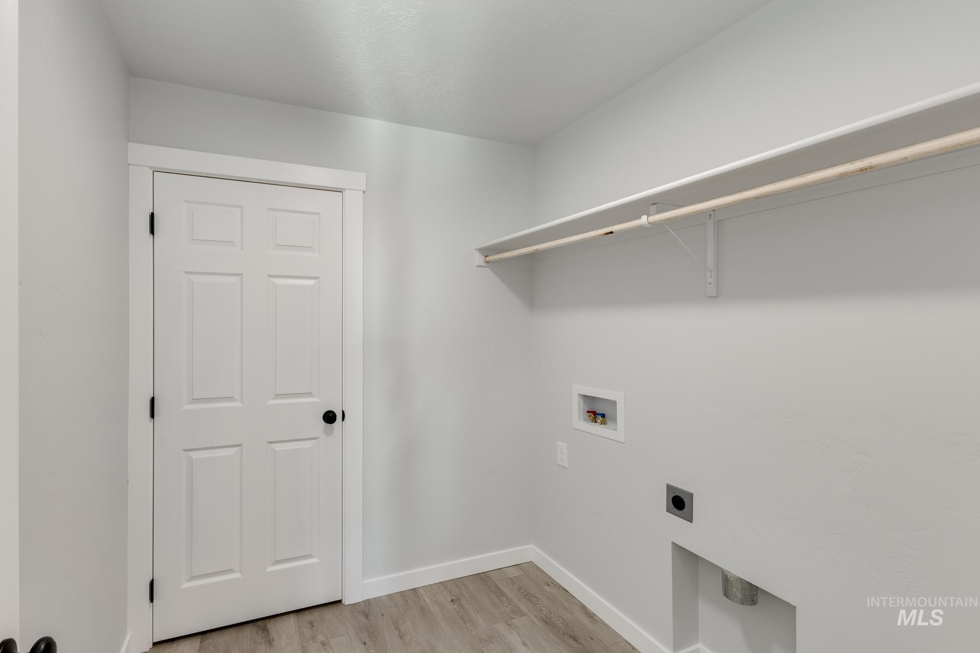 Laundry area featuring light wood-style flooring, washer hookup, and hookup for an electric dryer
