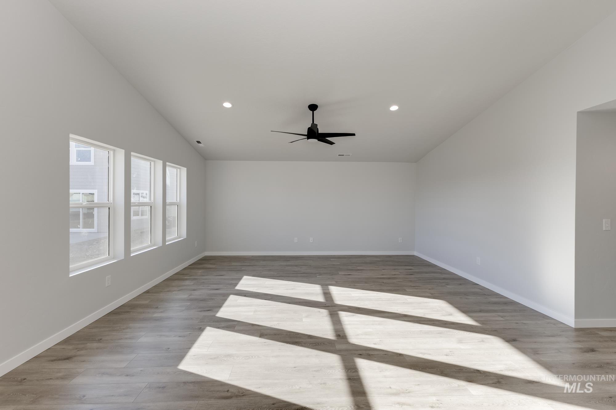 Unfurnished room featuring recessed lighting, ceiling fan, light wood-style floors, and vaulted ceiling