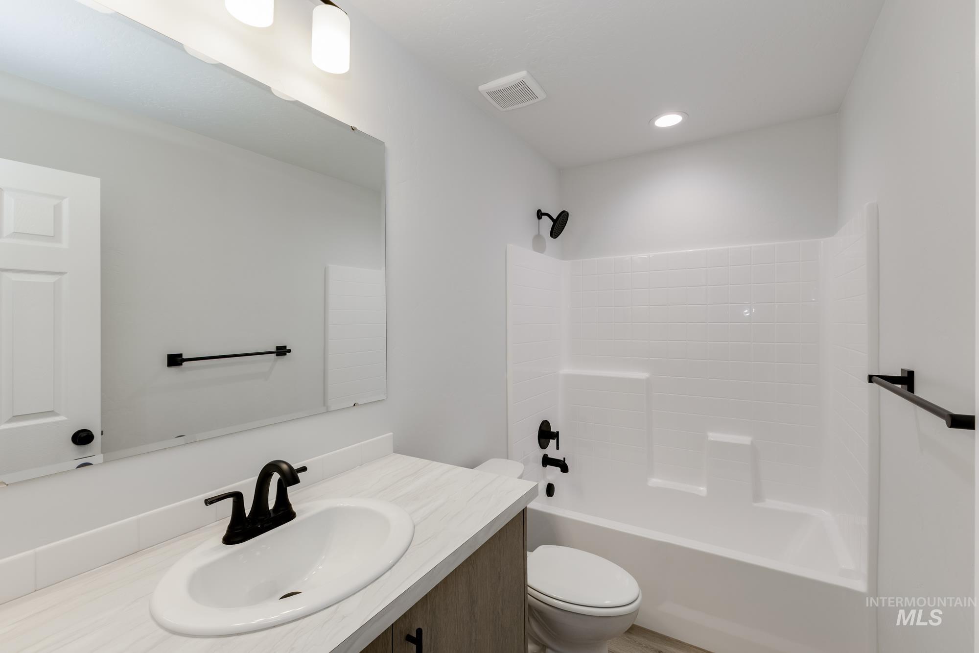 Full bathroom with vanity, tub / shower combination, and recessed lighting
