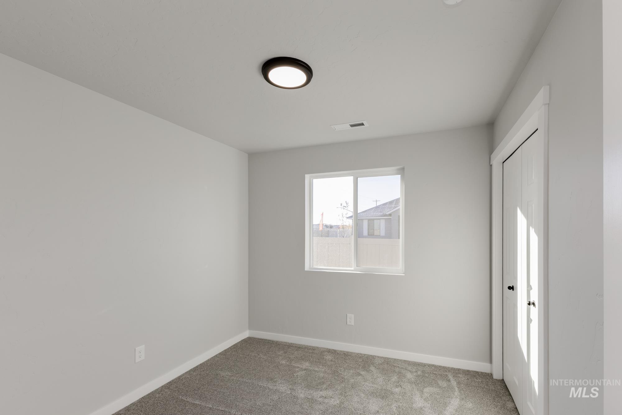Unfurnished bedroom featuring light carpet and baseboards