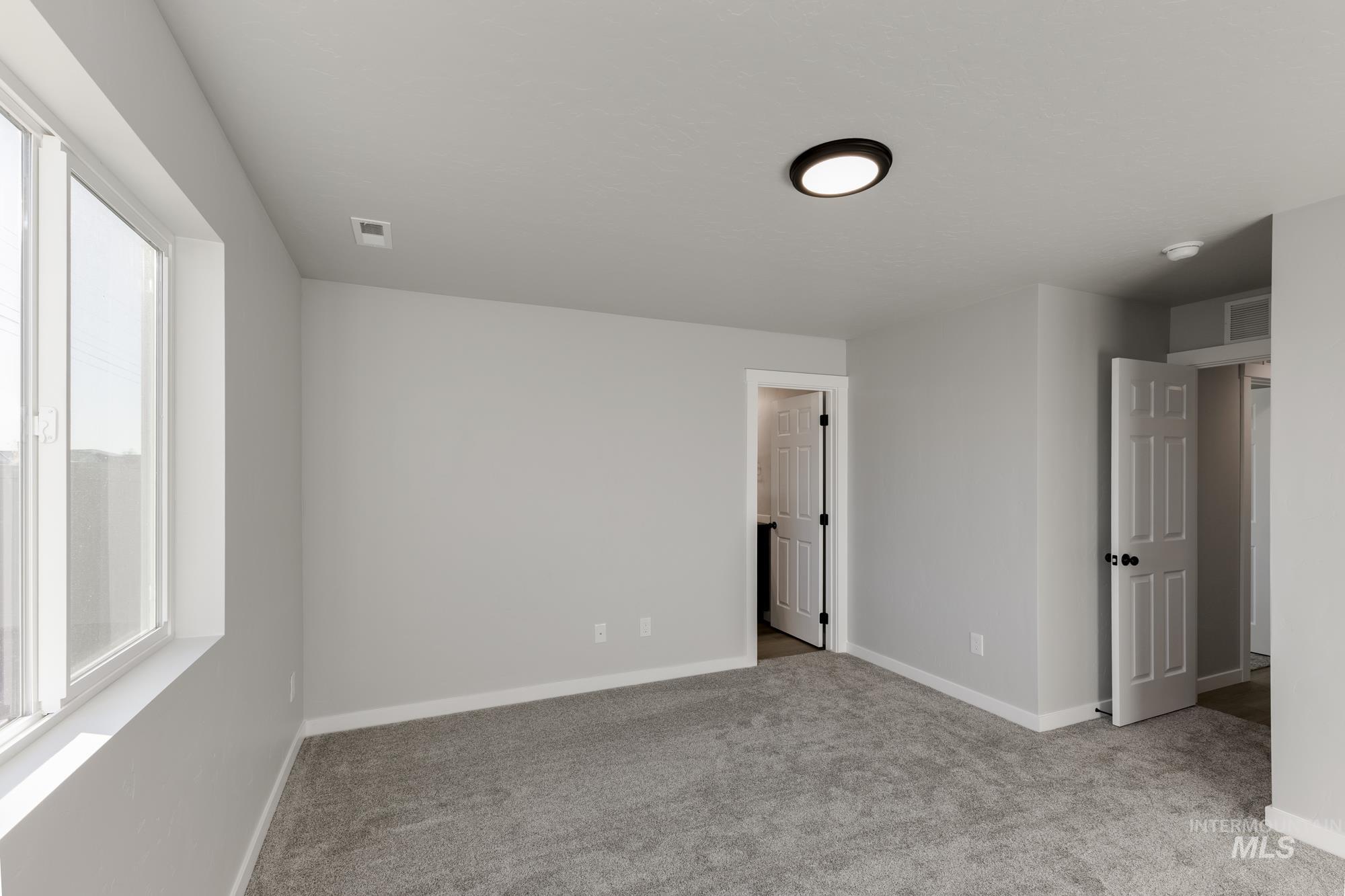 Unfurnished bedroom featuring light colored carpet and baseboards