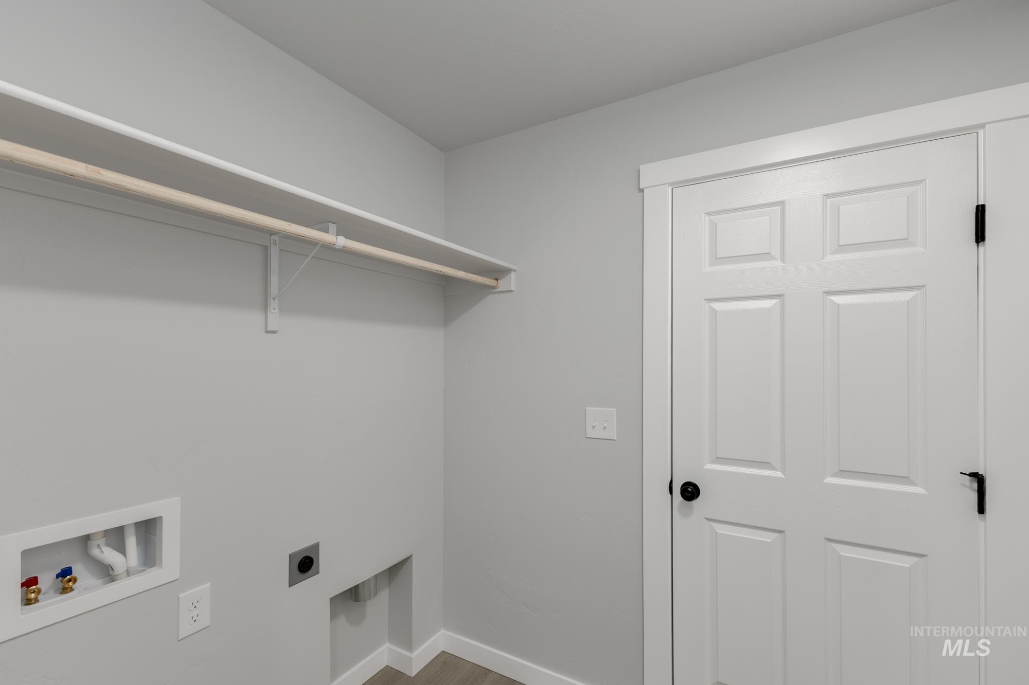 Laundry room with hookup for a washing machine, hookup for an electric dryer, and light wood finished floors