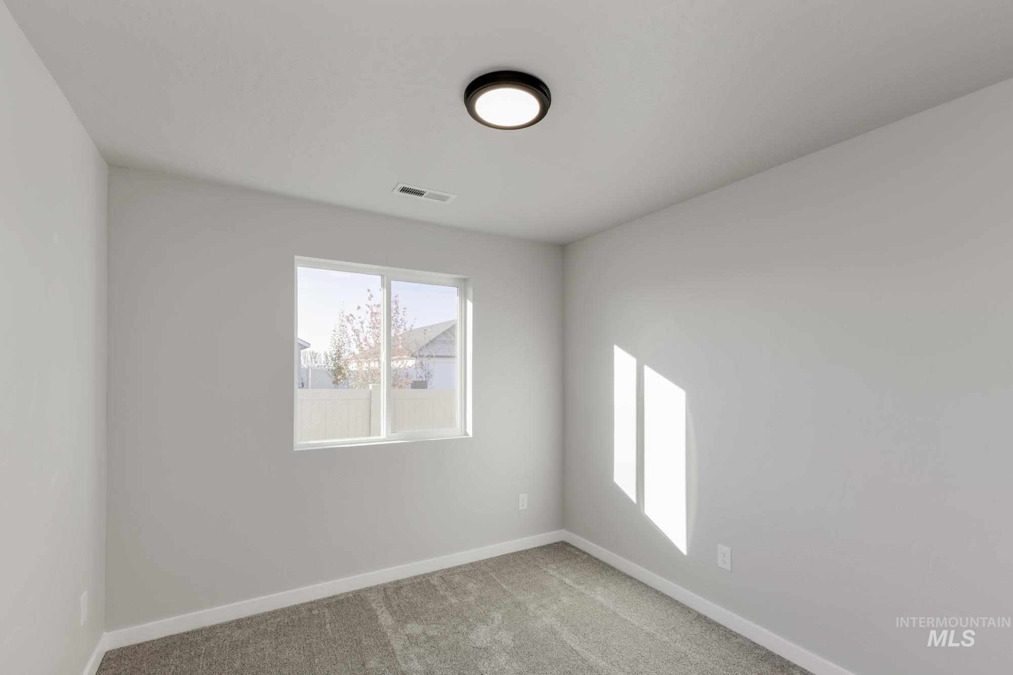 Unfurnished room featuring light colored carpet and baseboards