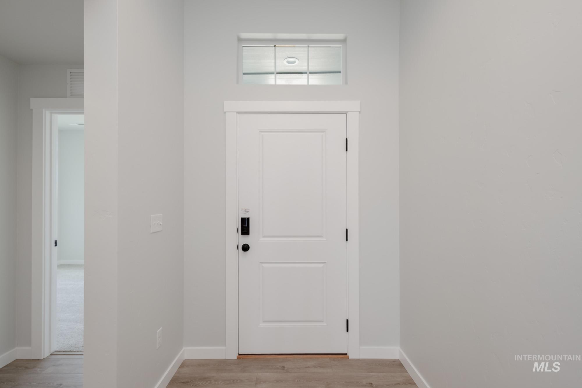 Doorway to outside featuring wood finished floors and baseboards