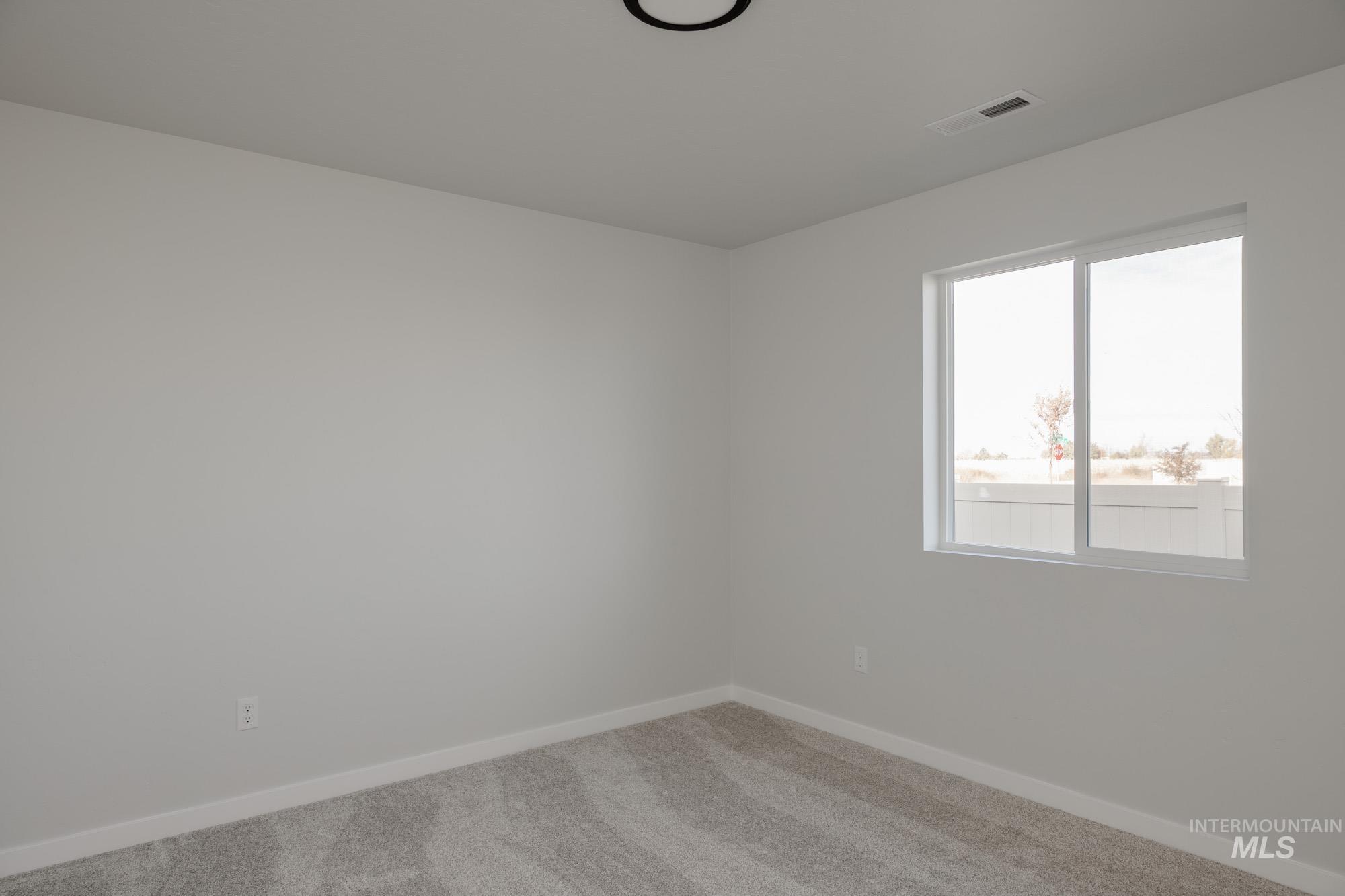 Spare room featuring baseboards and carpet flooring