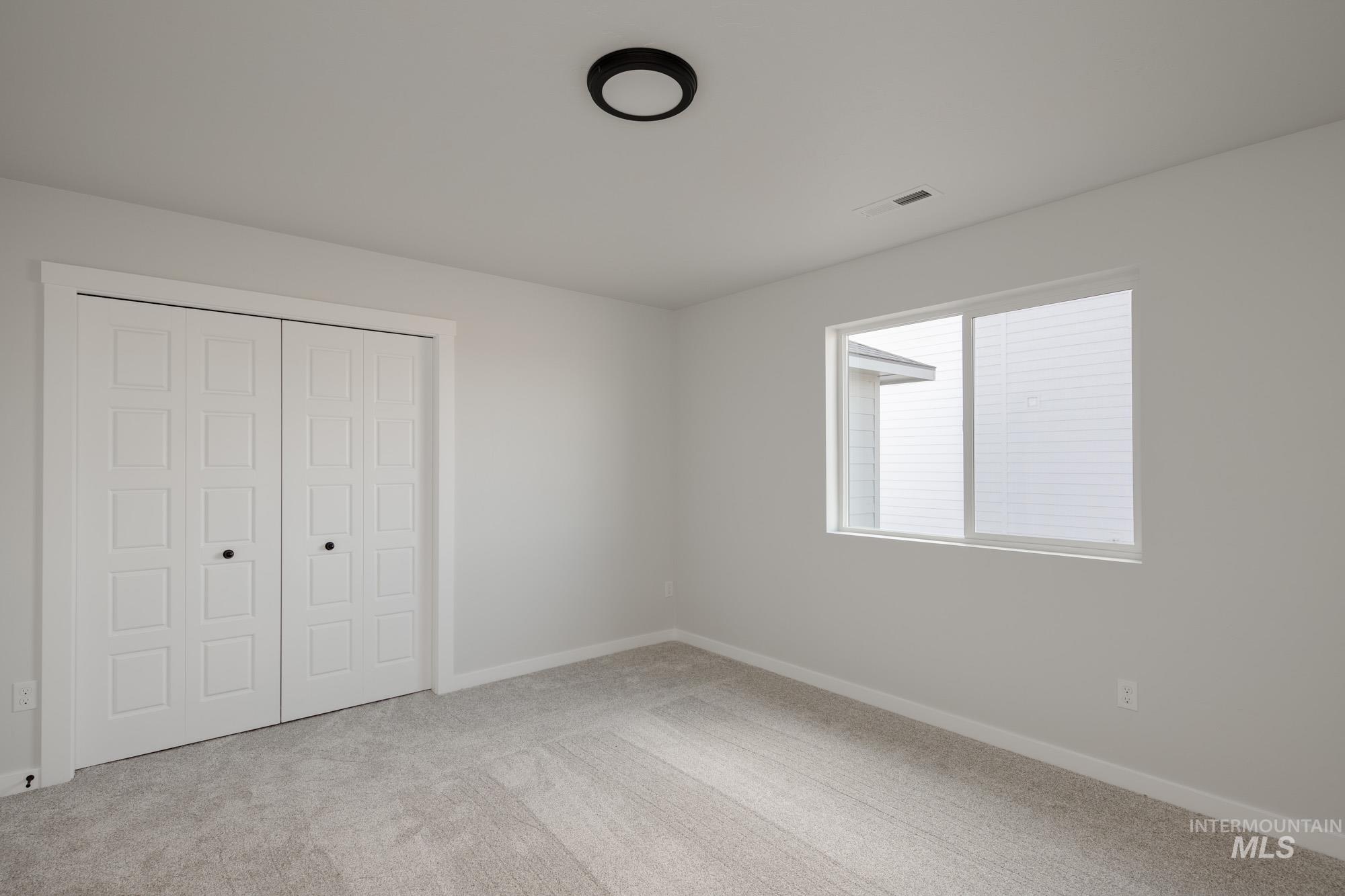 Unfurnished bedroom with a closet and light colored carpet