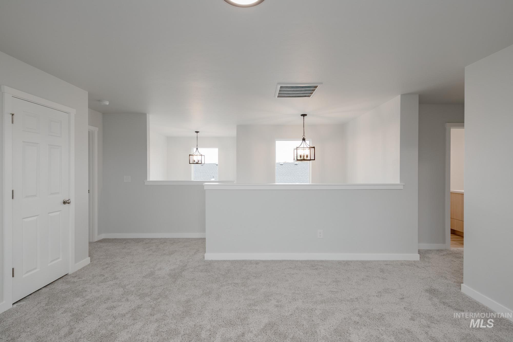 Empty room featuring light colored carpet and baseboards
