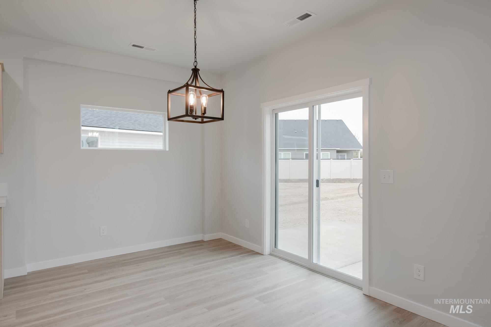 Unfurnished dining area featuring light wood-style floors and a chandelier