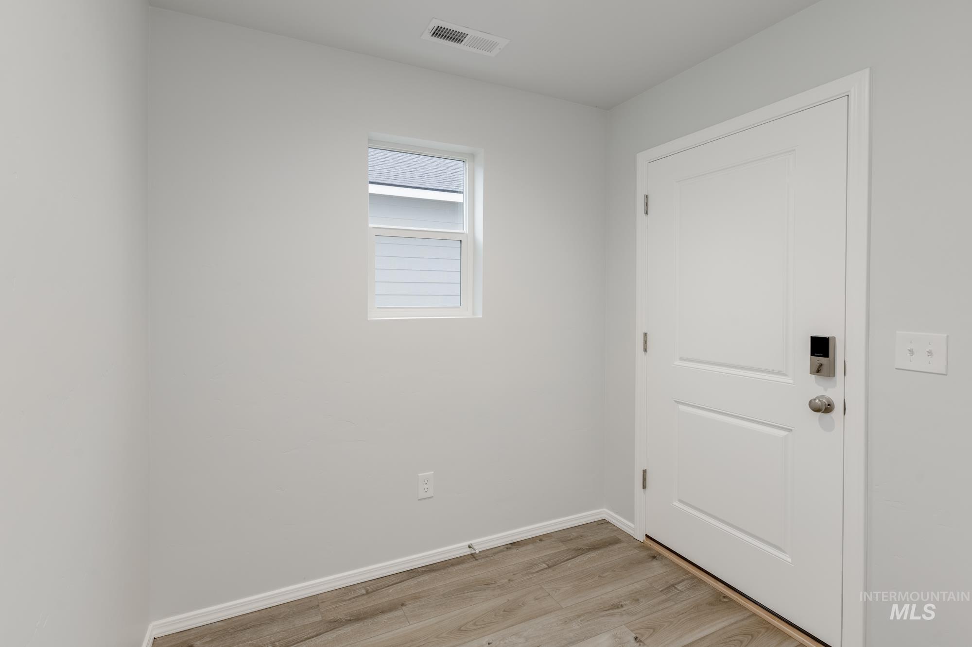 Doorway featuring wood finished floors and baseboards