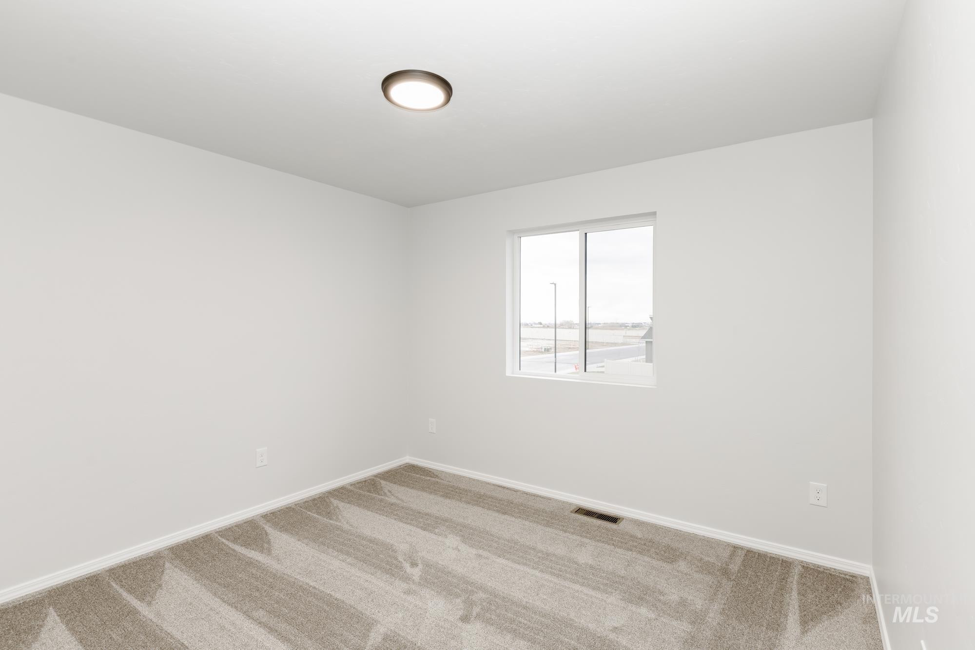 Carpeted empty room featuring baseboards