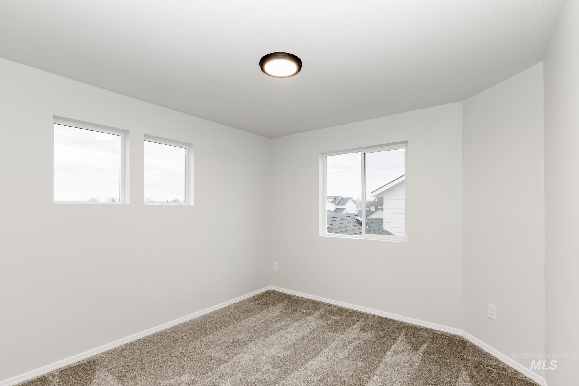 Carpeted spare room with baseboards