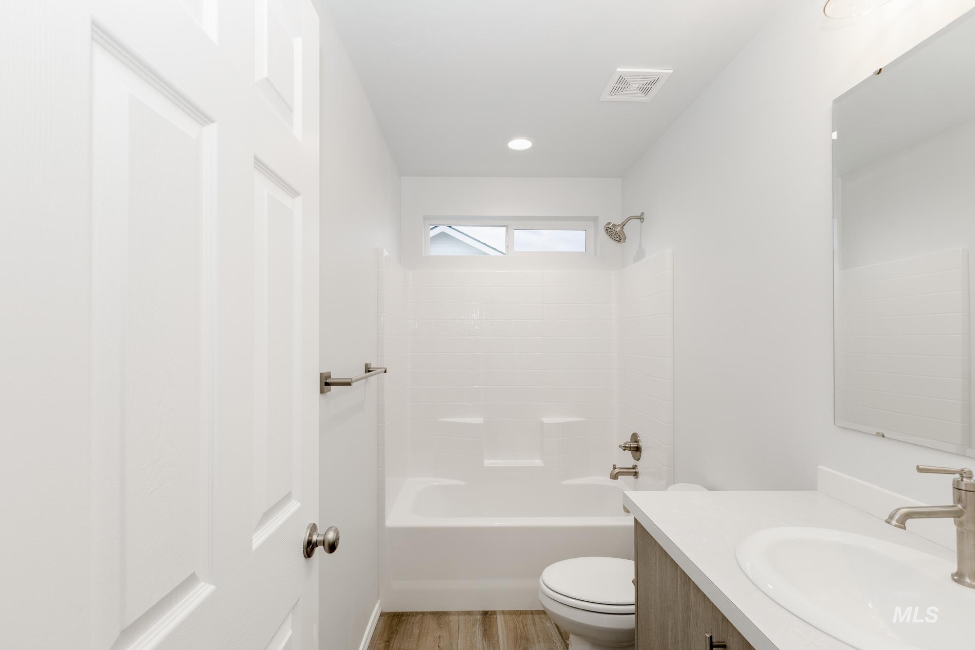 Bathroom featuring vanity, bathing tub / shower combination, and light wood-style floors