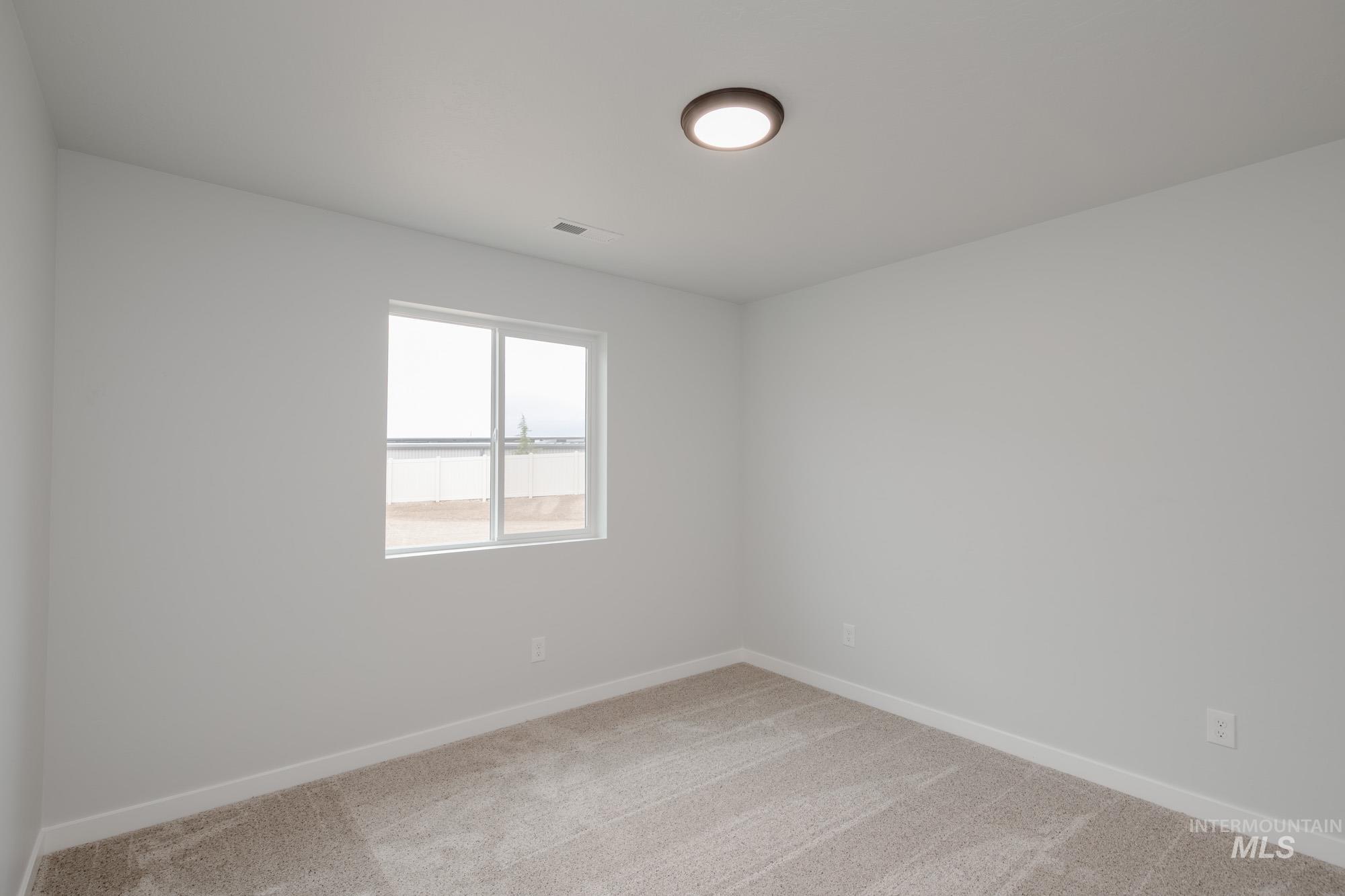 Unfurnished room featuring light carpet and baseboards