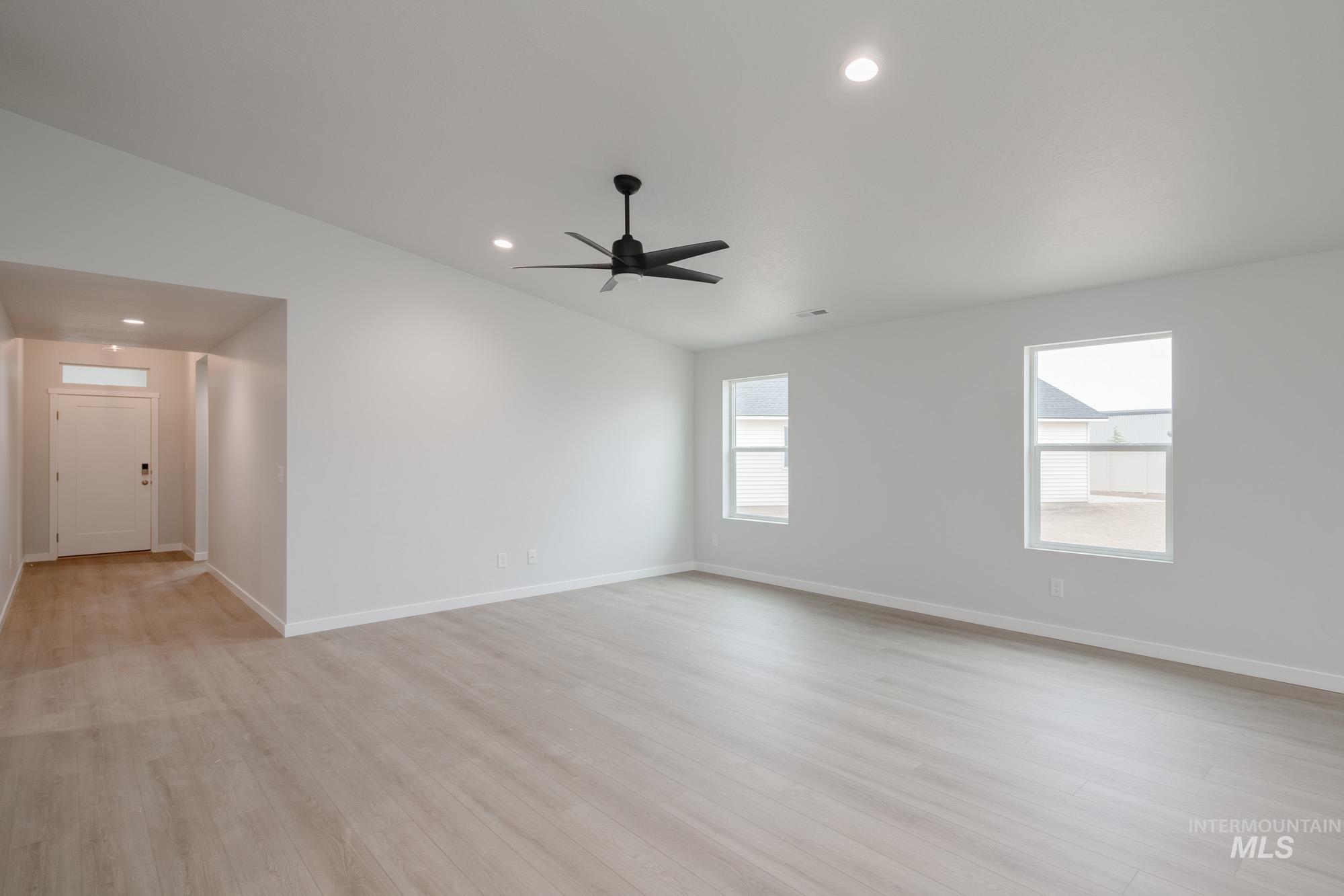 Unfurnished room with light wood-type flooring, recessed lighting, vaulted ceiling, and a ceiling fan