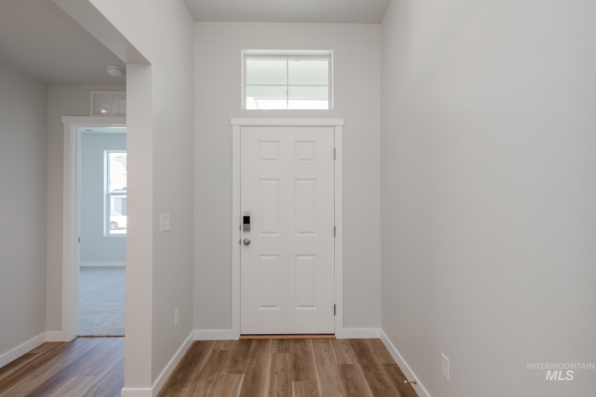 Foyer entrance featuring light wood-style flooring and baseboards
