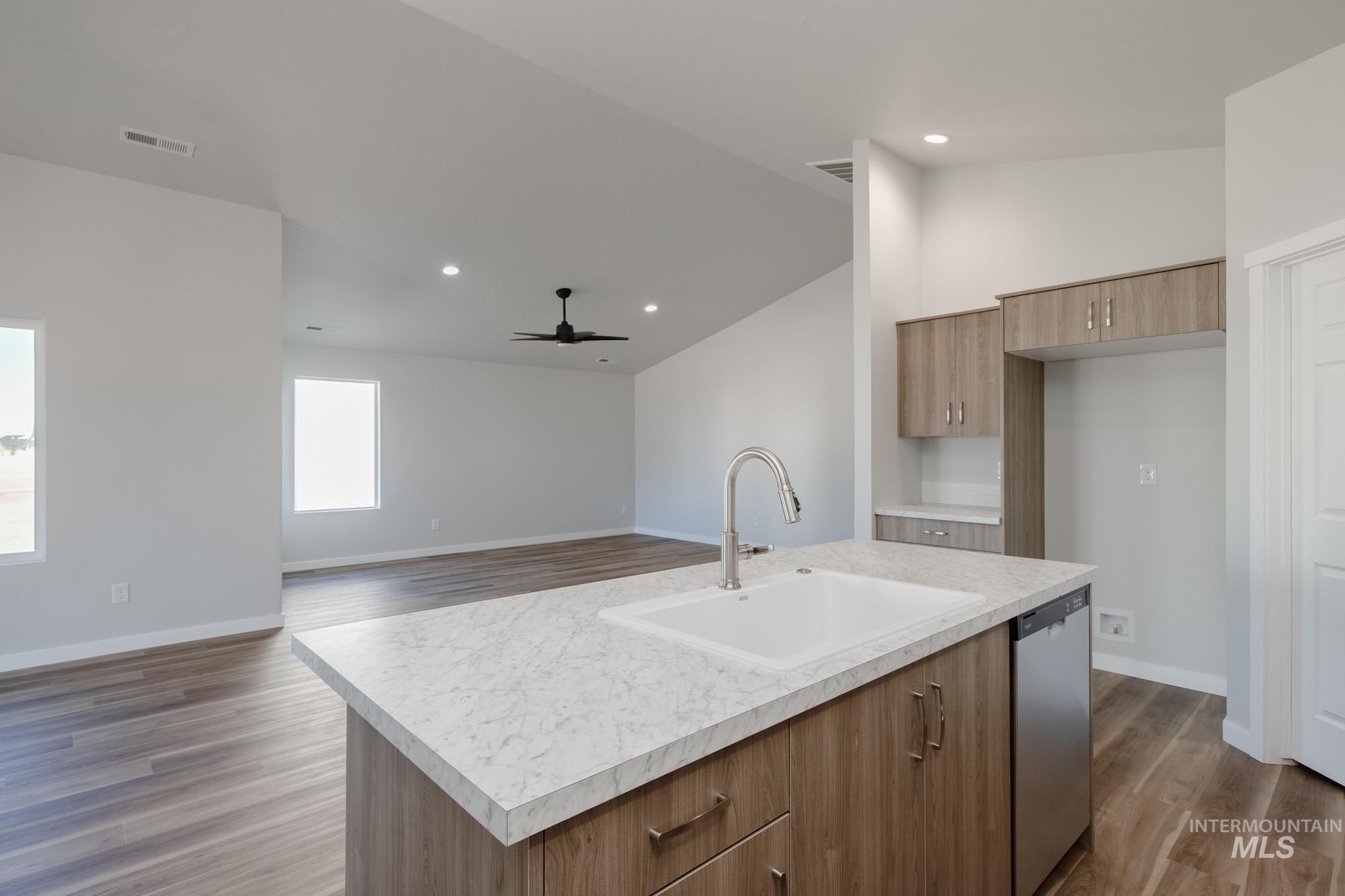 Kitchen with brown cabinets, light countertops, light wood-style floors, modern cabinets, and recessed lighting