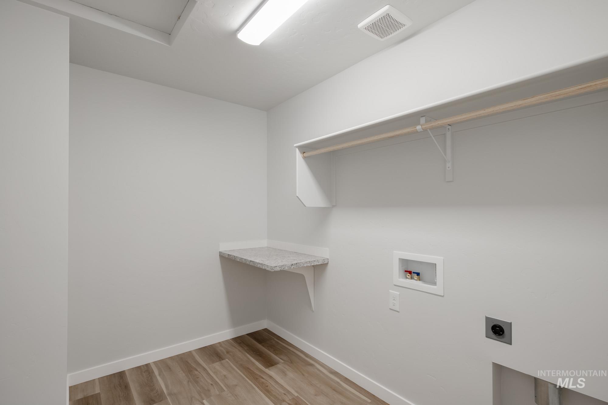 Laundry room featuring light wood finished floors, hookup for a washing machine, and hookup for an electric dryer