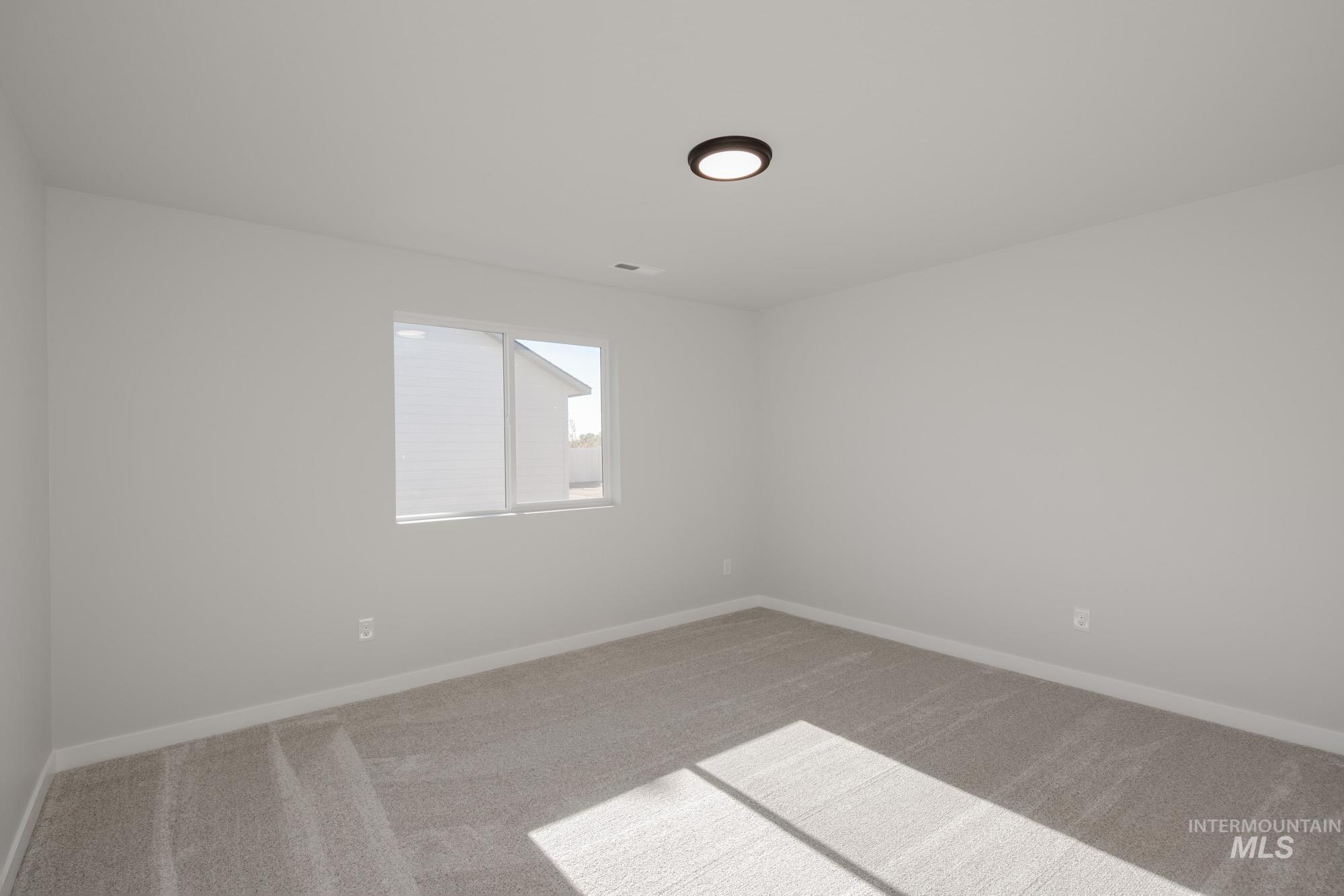 Empty room with light carpet and baseboards