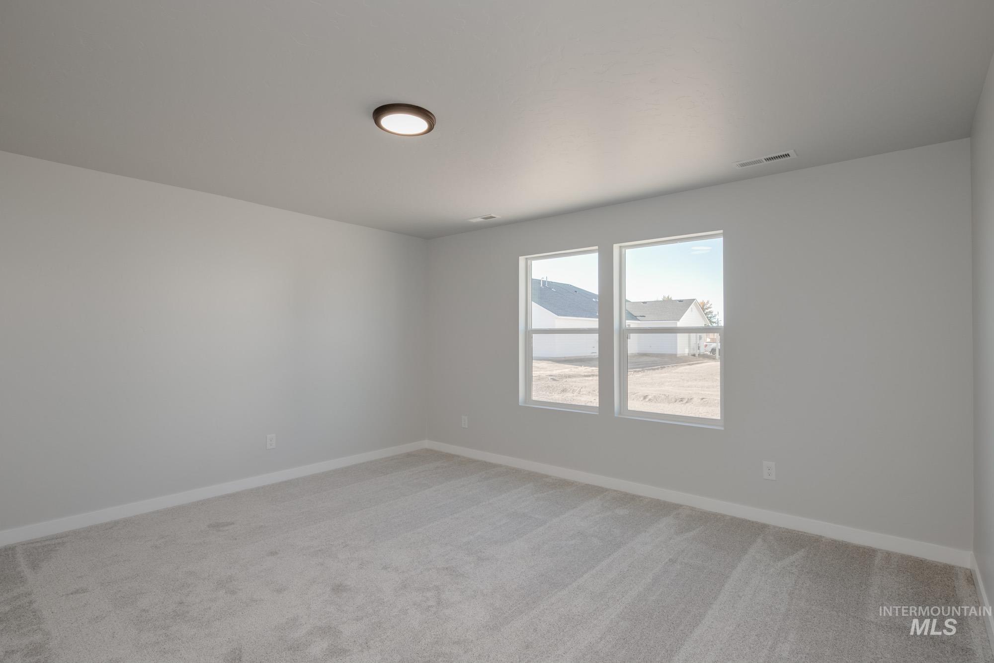 Spare room featuring baseboards and light colored carpet