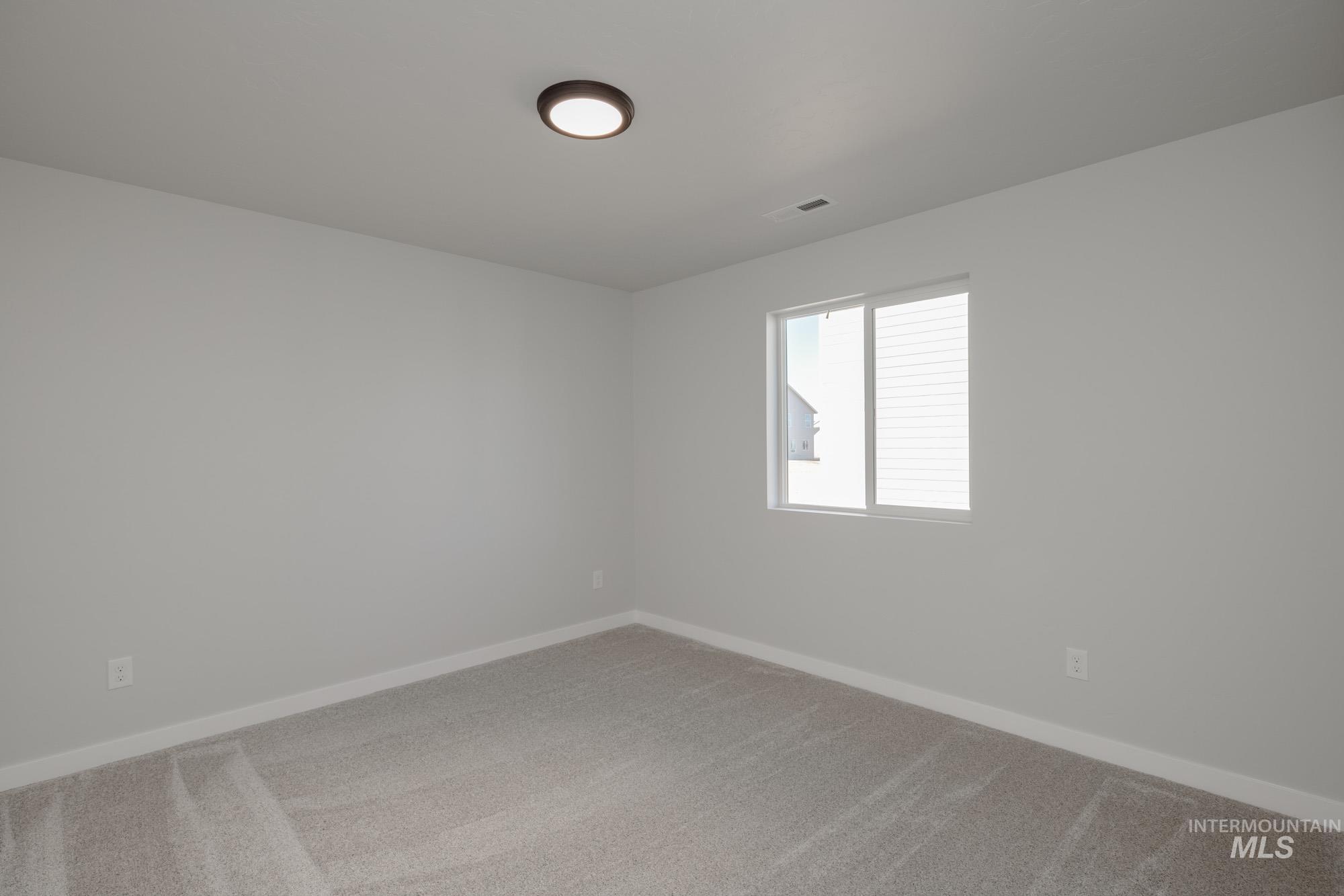 Spare room featuring light colored carpet