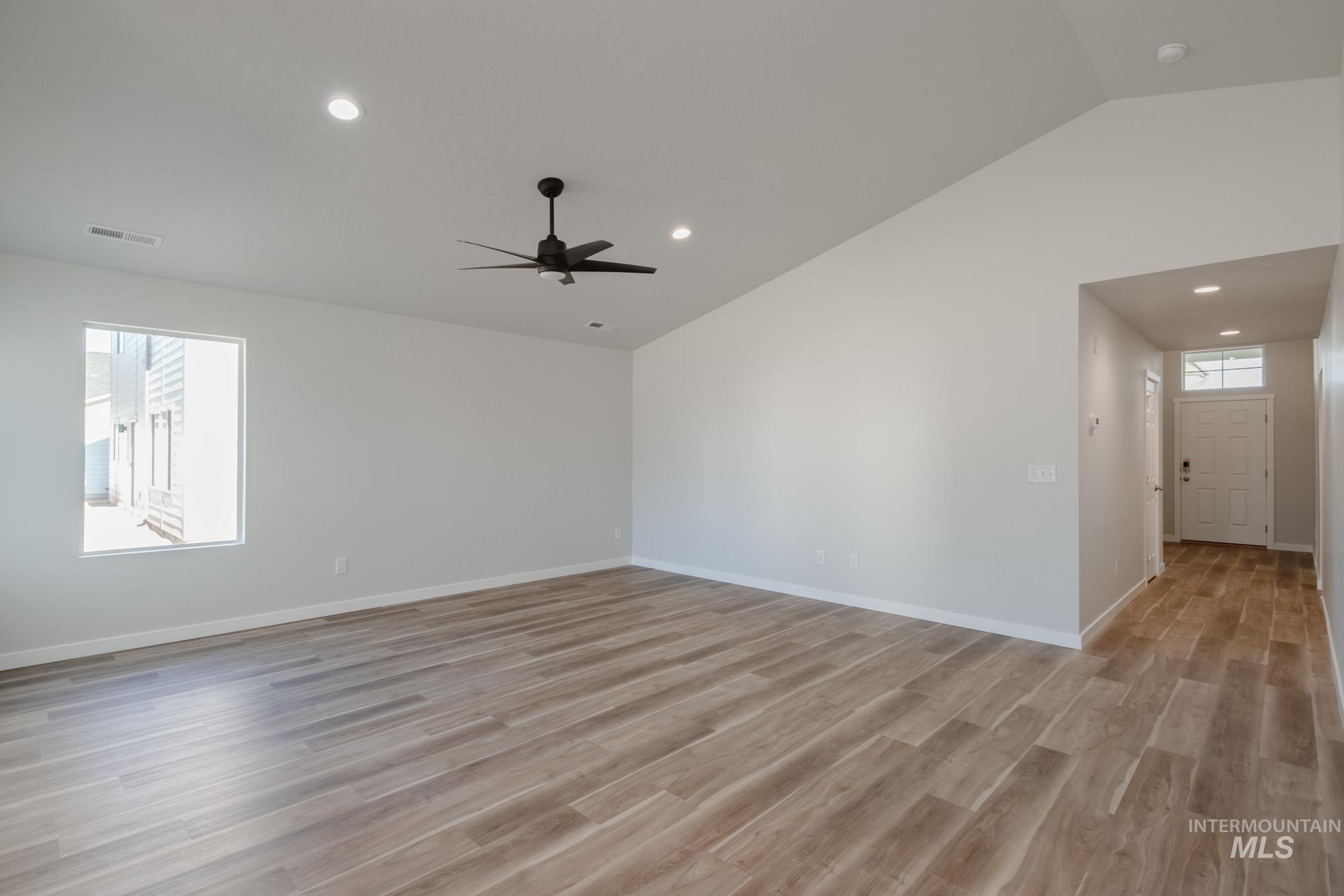 Spare room with lofted ceiling, light wood finished floors, and recessed lighting