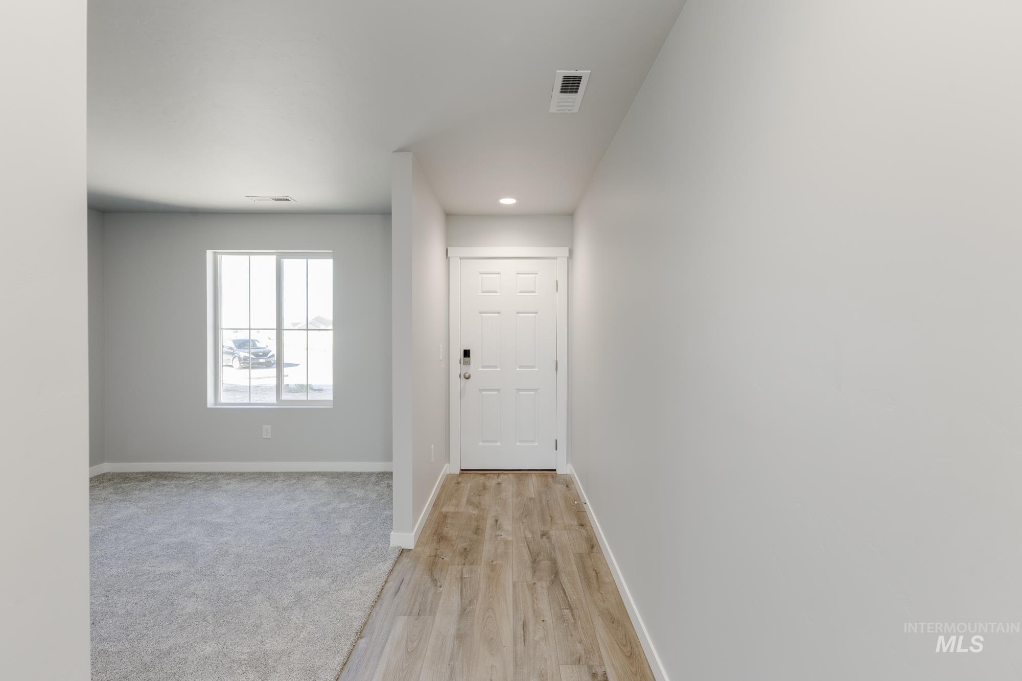 Entryway with wood finished floors and recessed lighting