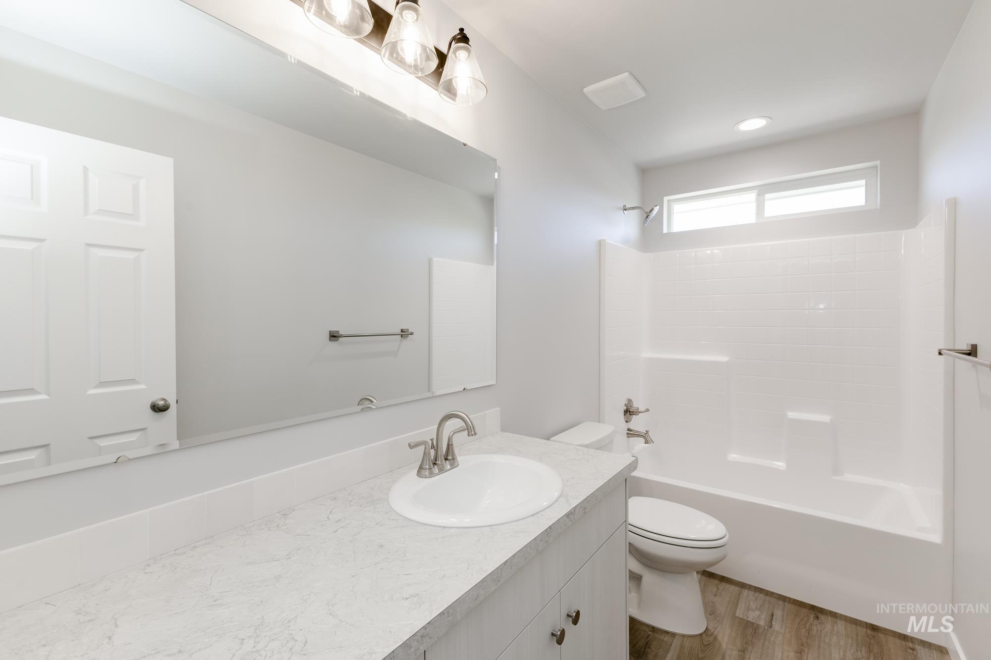Bathroom with vanity, tub / shower combination, and wood finished floors