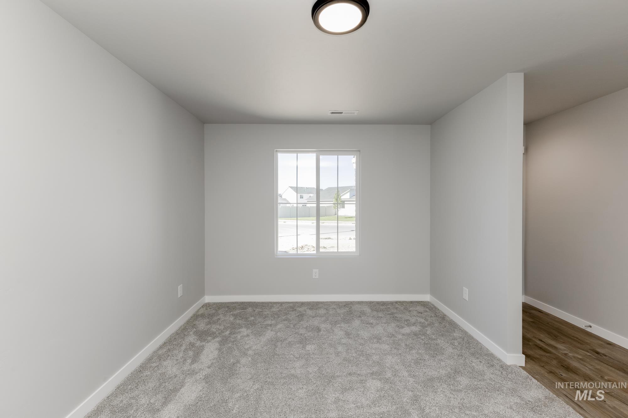 Spare room with light carpet and baseboards