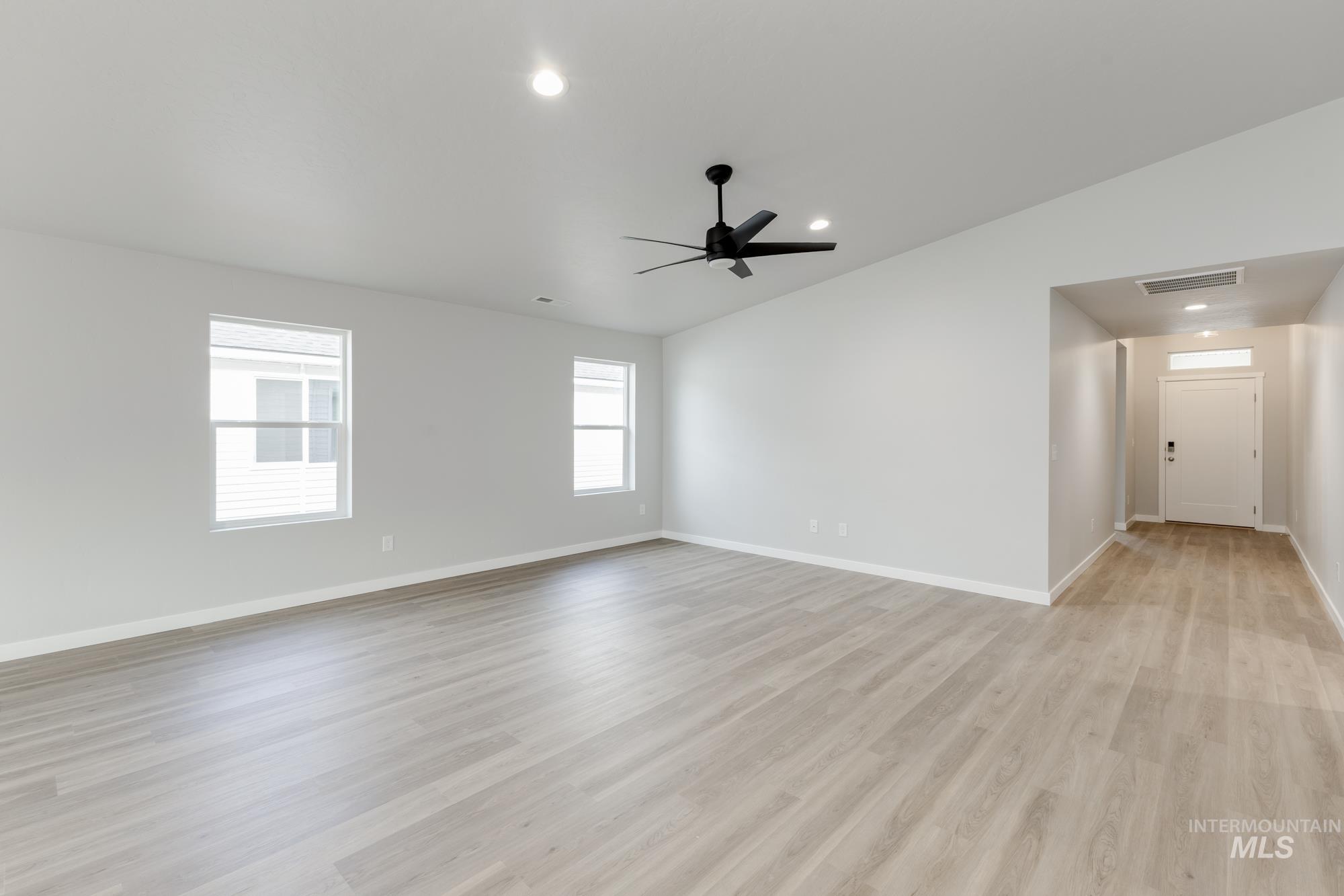 Empty room featuring lofted ceiling, recessed lighting, light wood-style floors, and ceiling fan