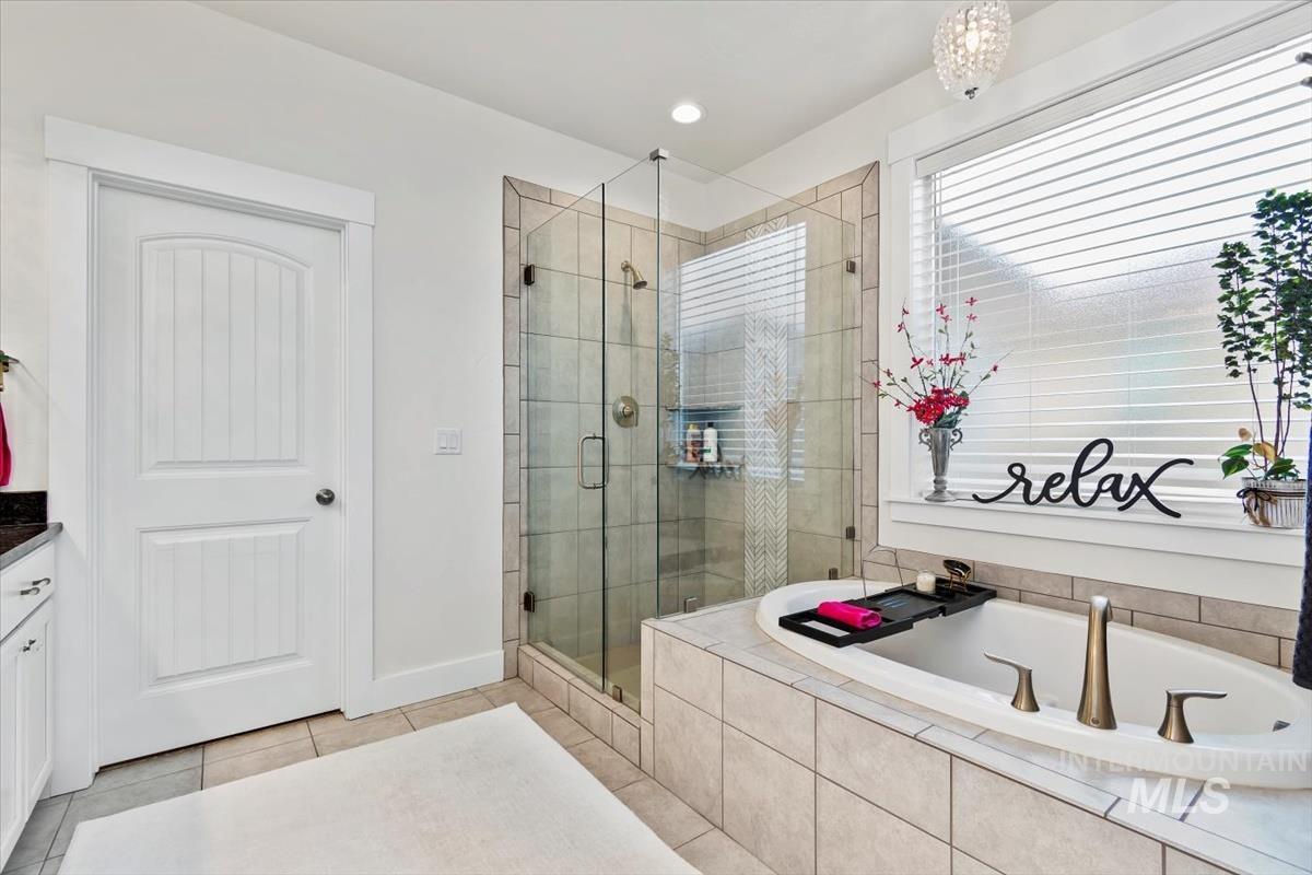 Bathroom featuring a bath, a stall shower, light tile patterned floors, vanity, and recessed lighting