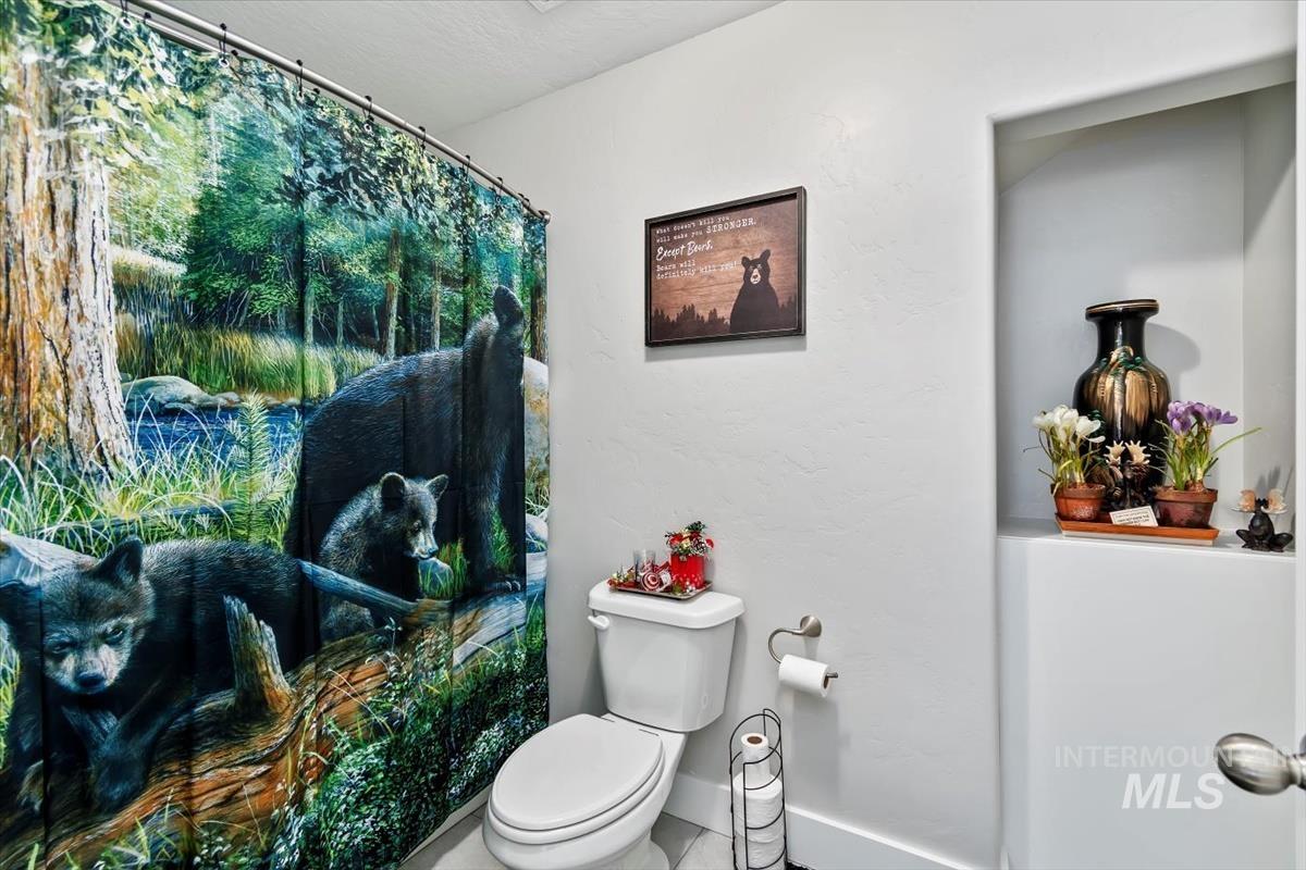 Bathroom featuring a shower with shower curtain and a textured wall