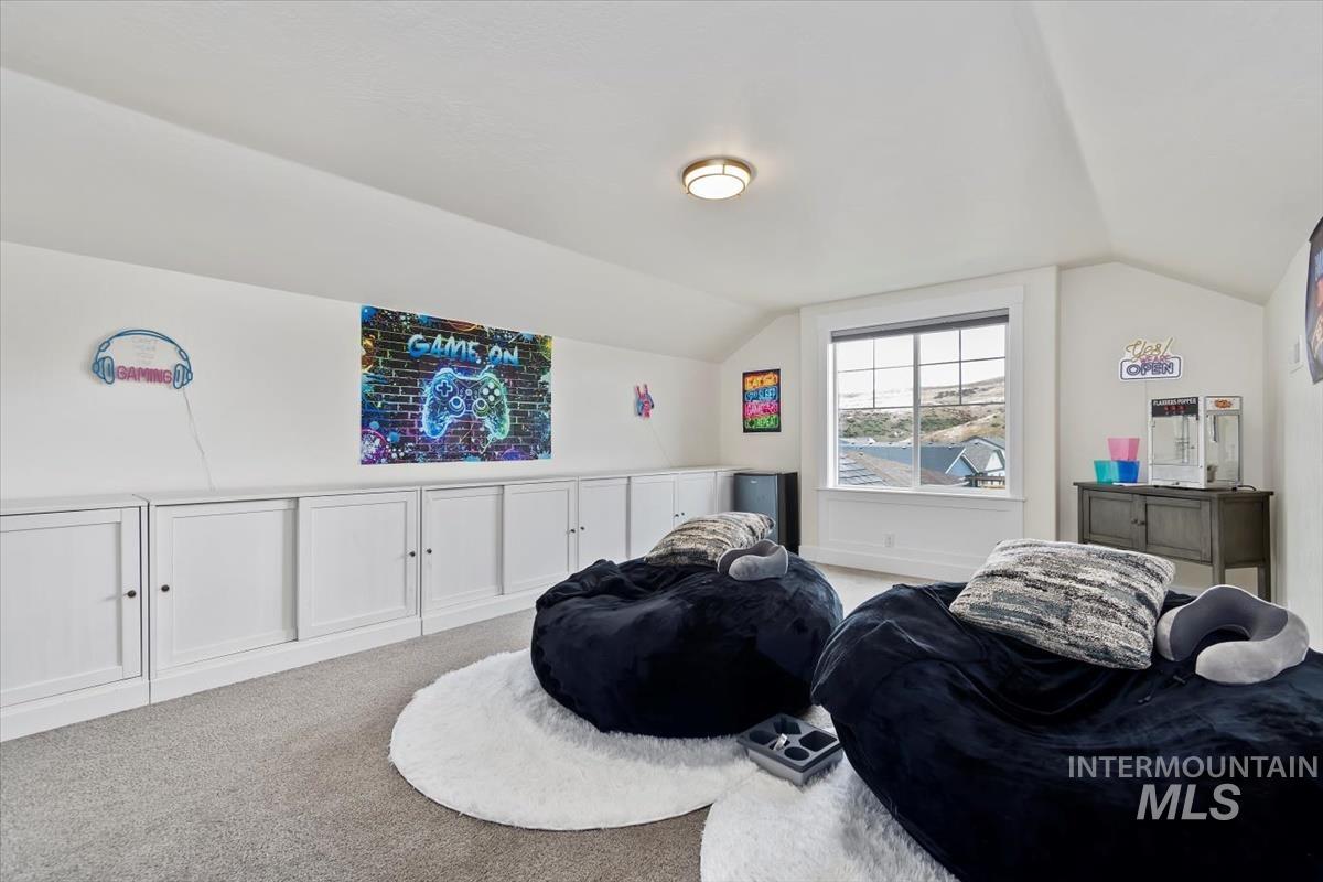 Carpeted bedroom featuring vaulted ceiling
