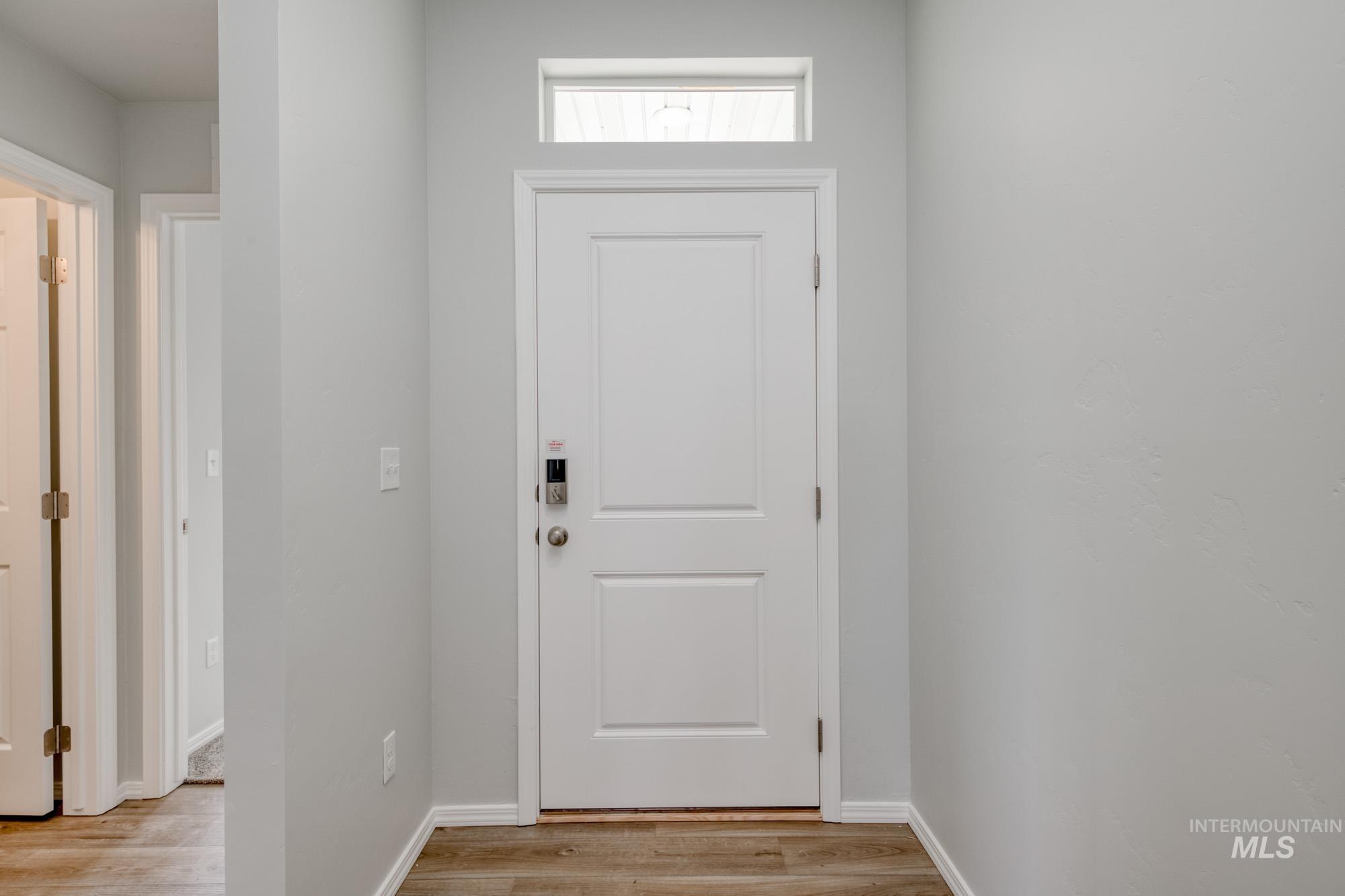Doorway to outside featuring wood finished floors and baseboards