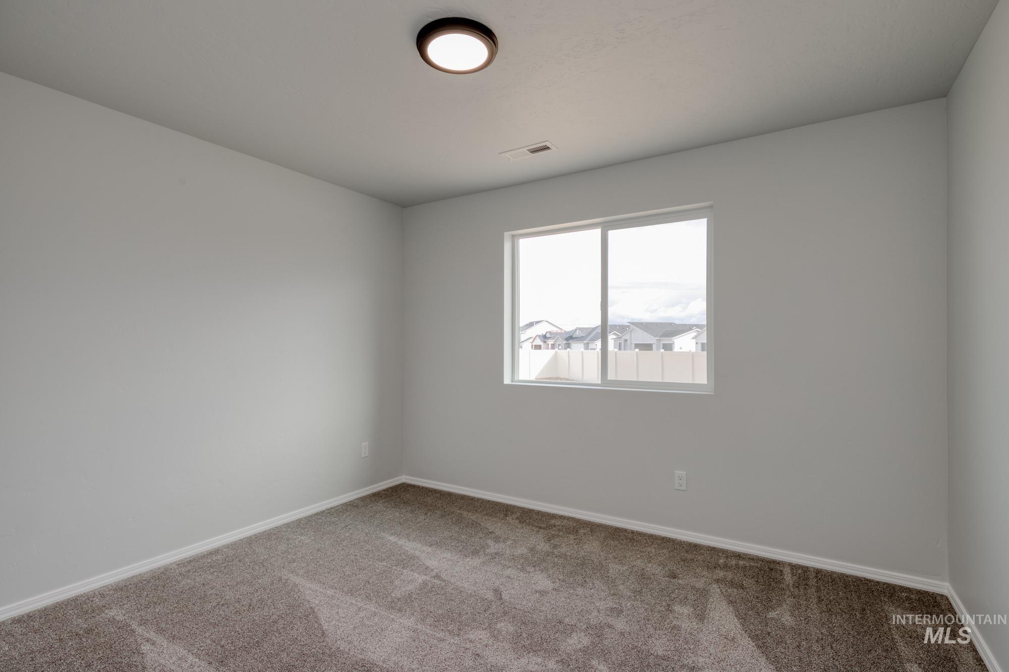 Empty room with carpet and baseboards