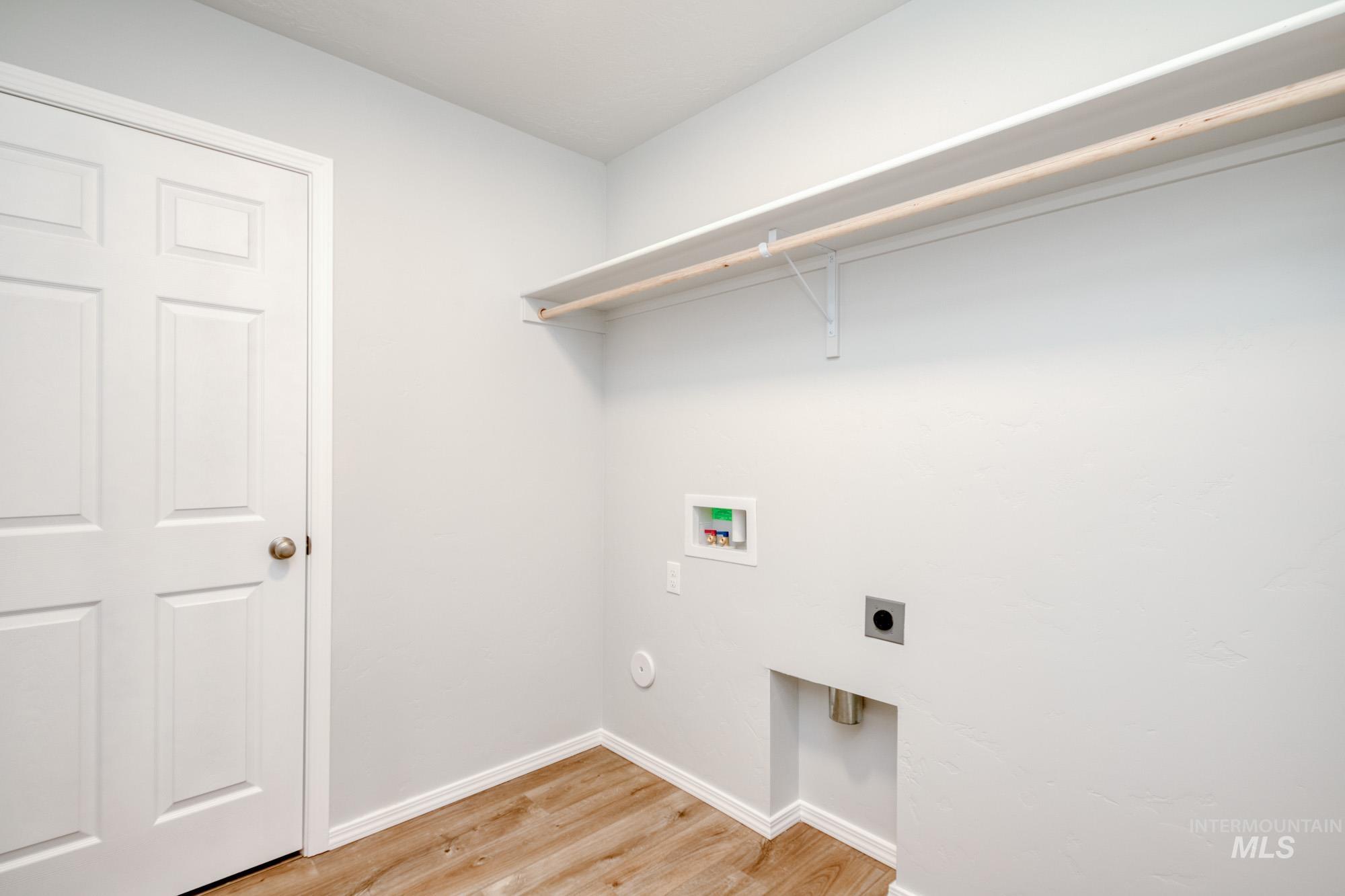 Laundry room with light wood finished floors, electric dryer hookup, and hookup for a washing machine