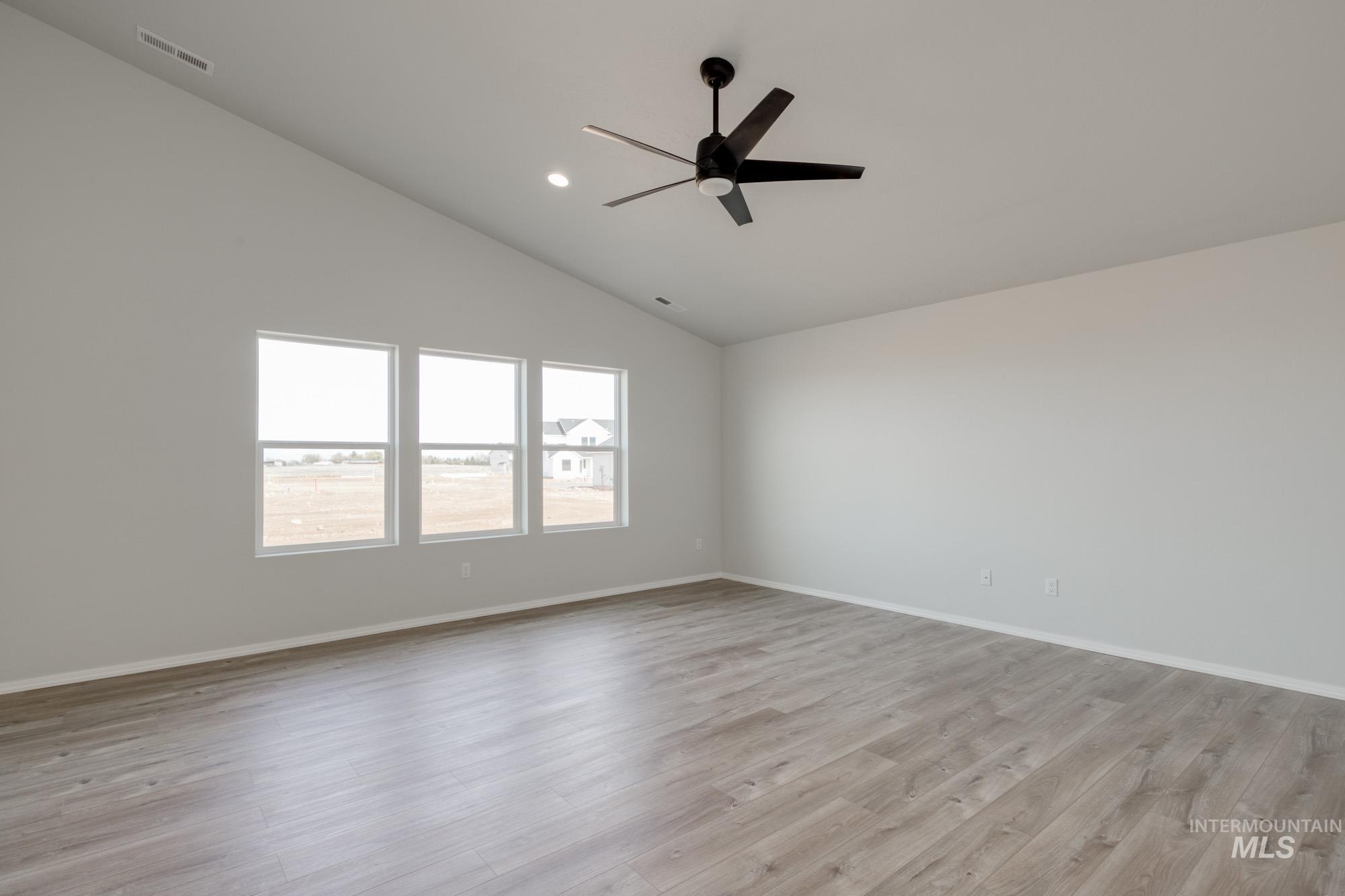 Unfurnished room with light wood-style floors, lofted ceiling, ceiling fan, and recessed lighting