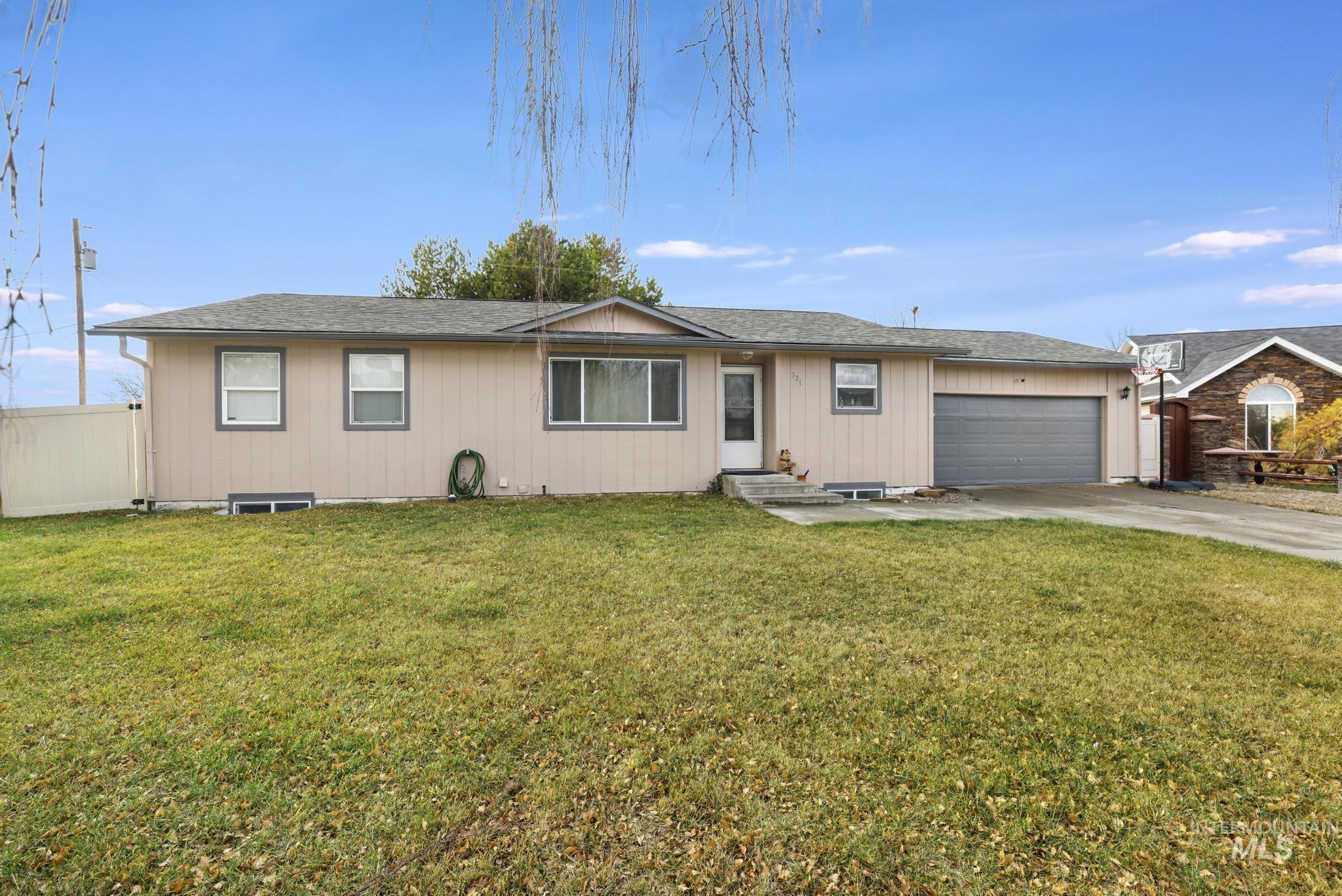 Ranch-style home with driveway, a shingled roof, and an attached garage