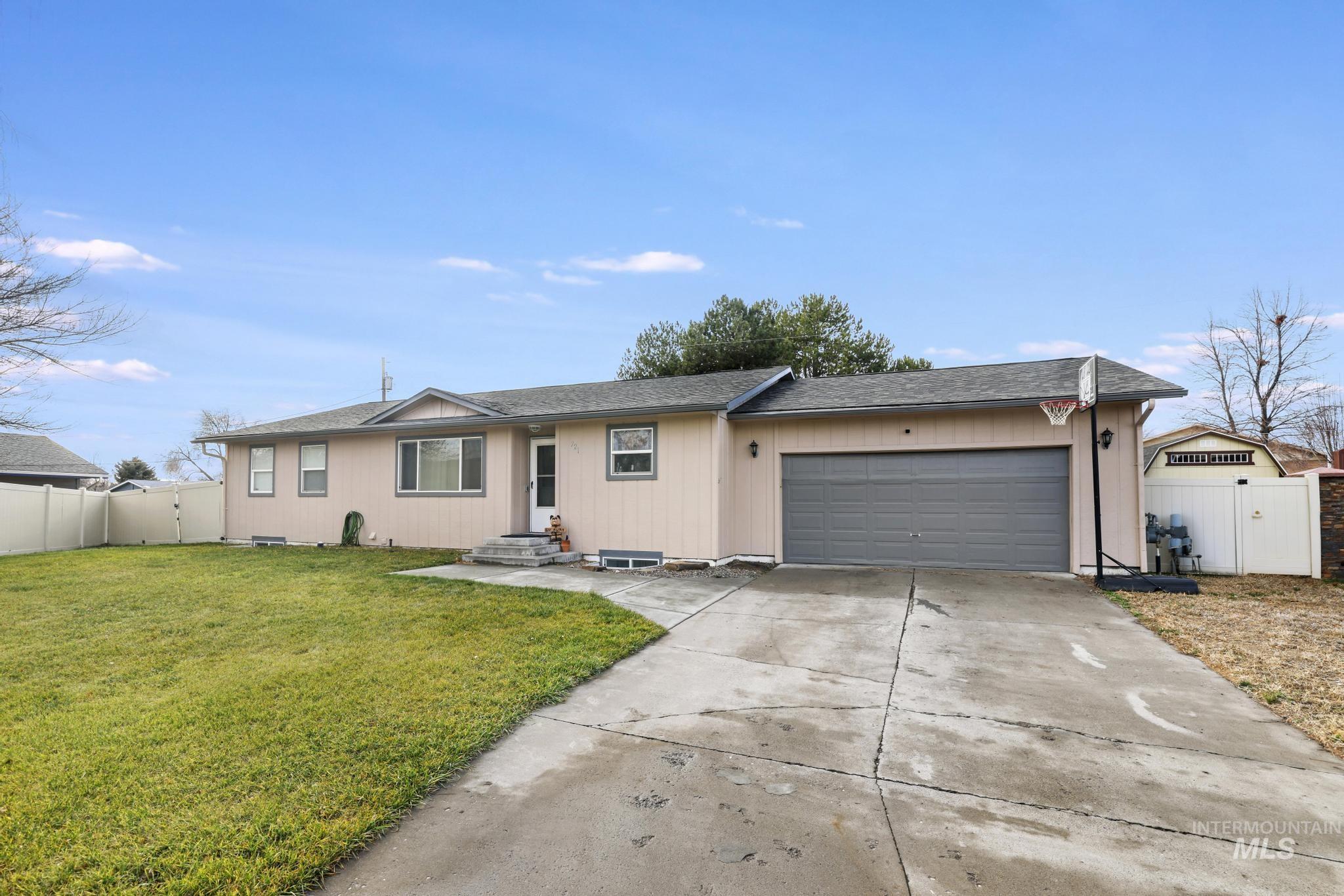 Ranch-style home featuring a gate, roof with shingles, driveway, and a garage