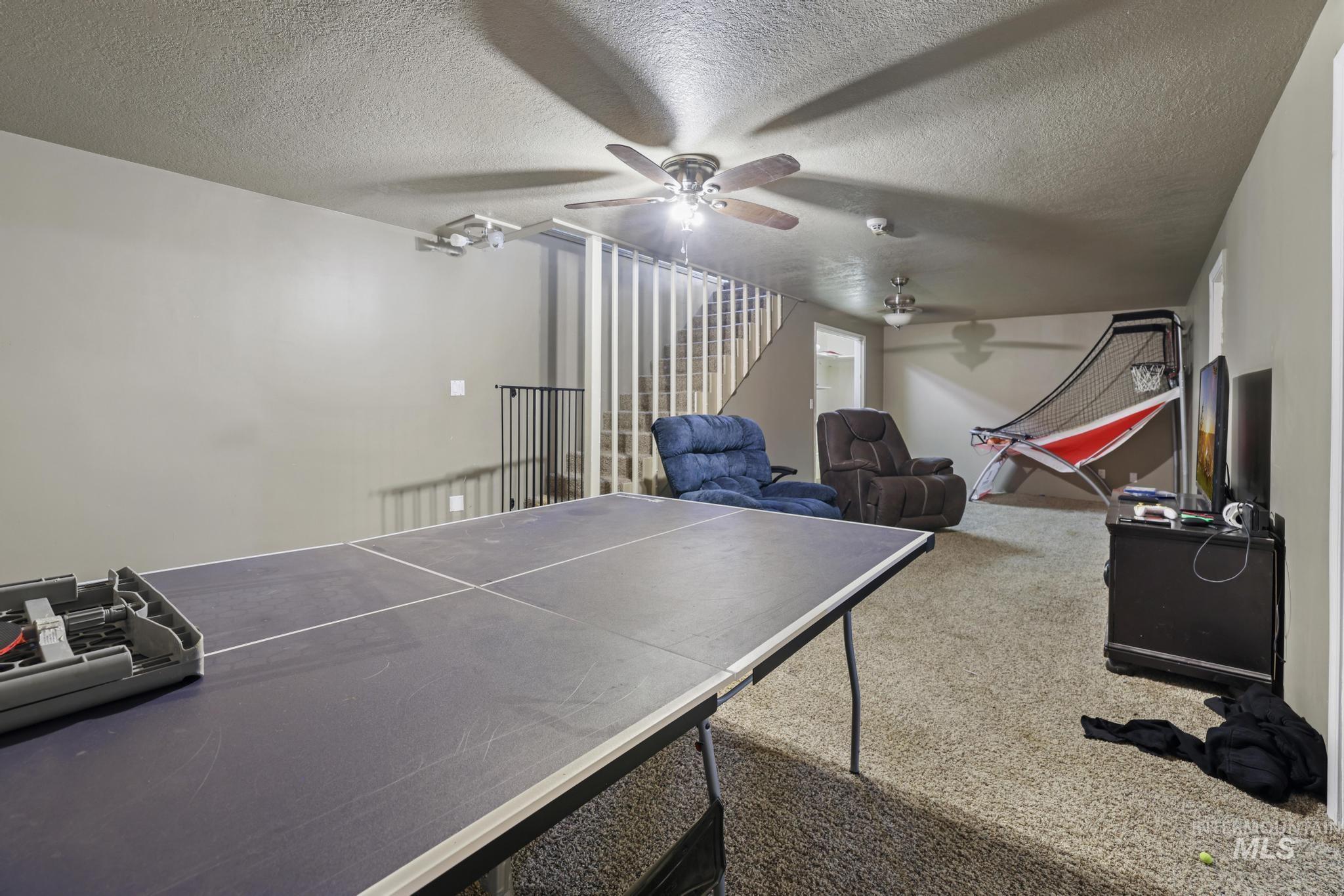 Game room with carpet, ceiling fan, and a textured ceiling