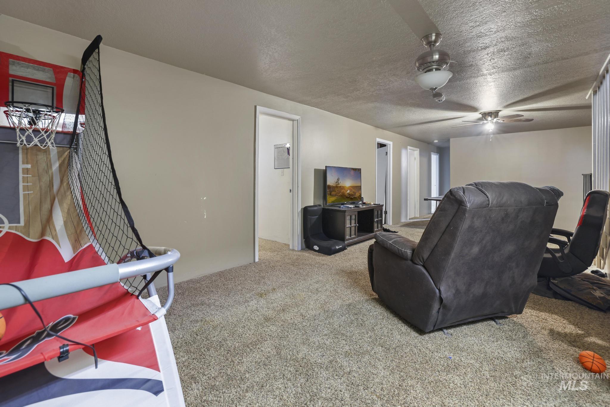Home theater featuring carpet and a textured ceiling